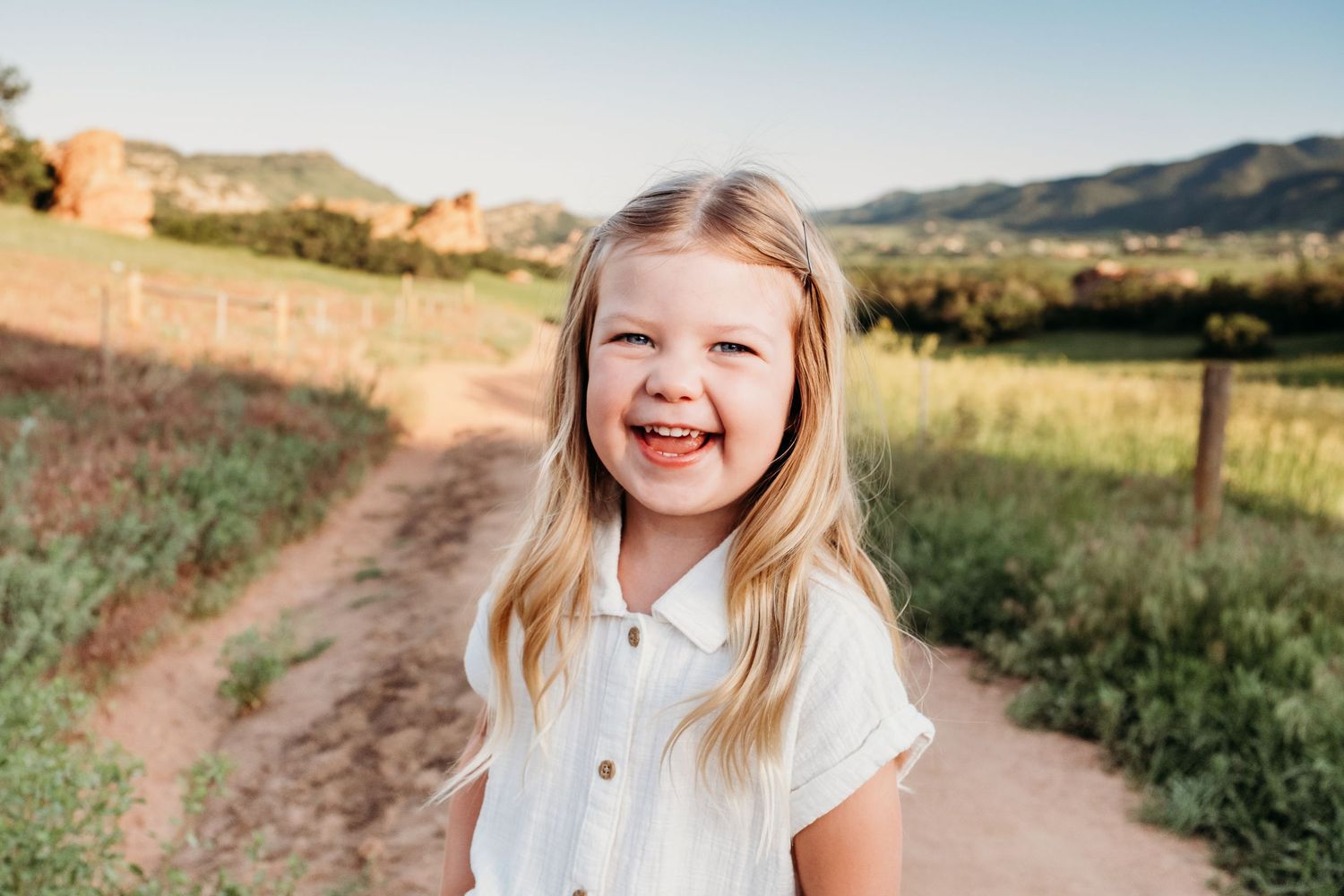 Close up of young girl smiling widely on trailhead path at South Valley Park.