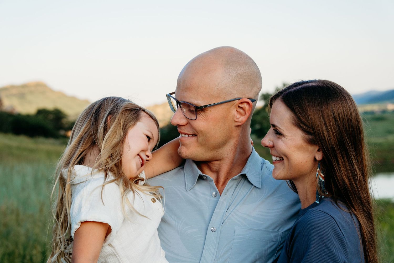South Valley Park Mini Session with family of three - close up of family all smiling at one another.