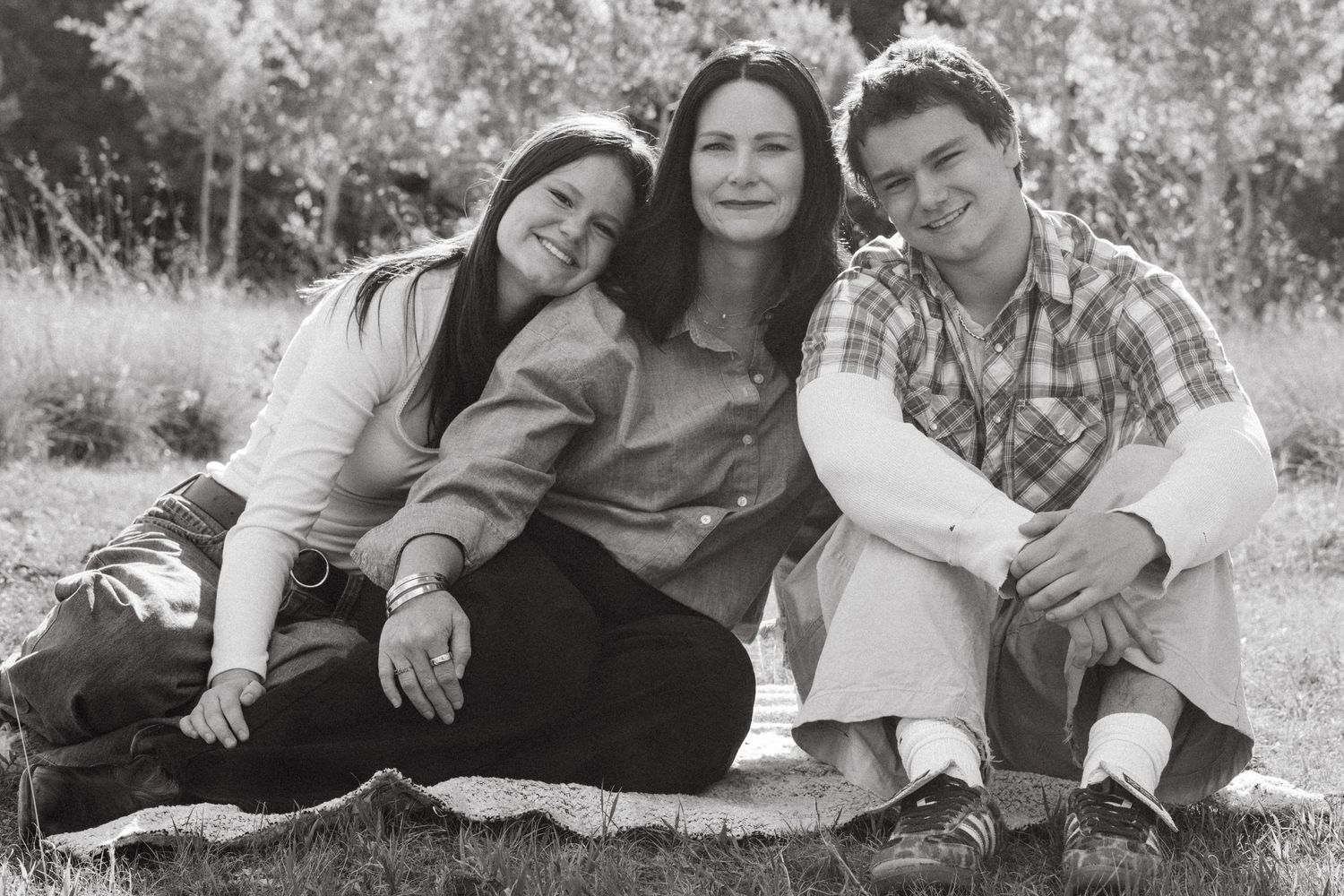 Black and white of mother with teenage children in Colorado Mountains.