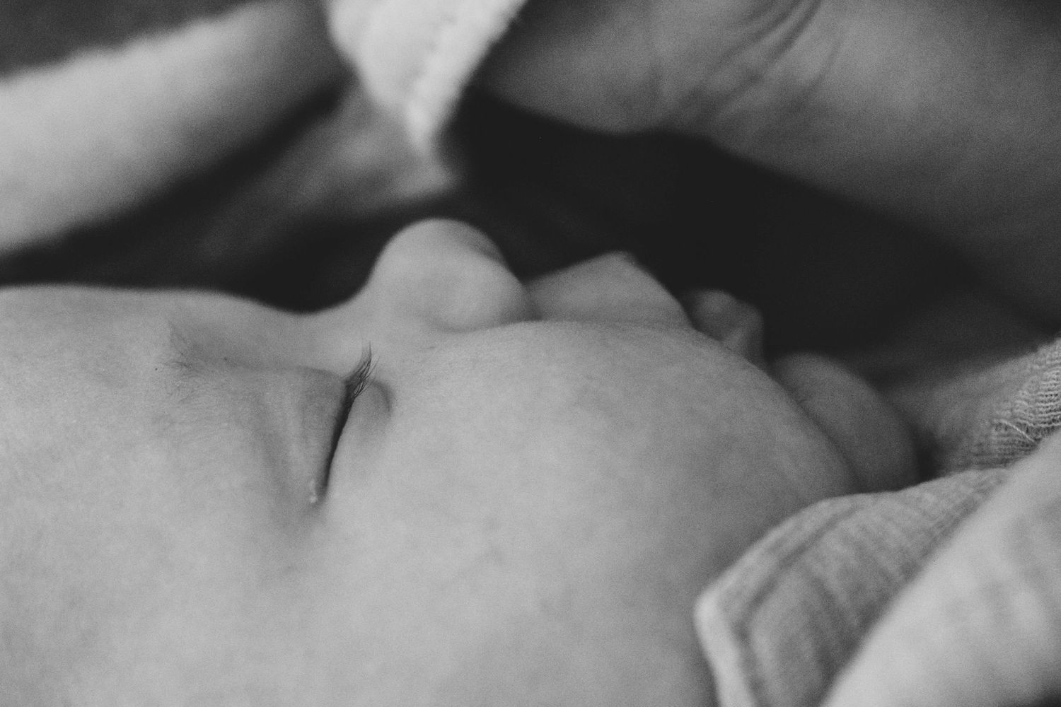 Black and white profile of newborn baby sleeping.