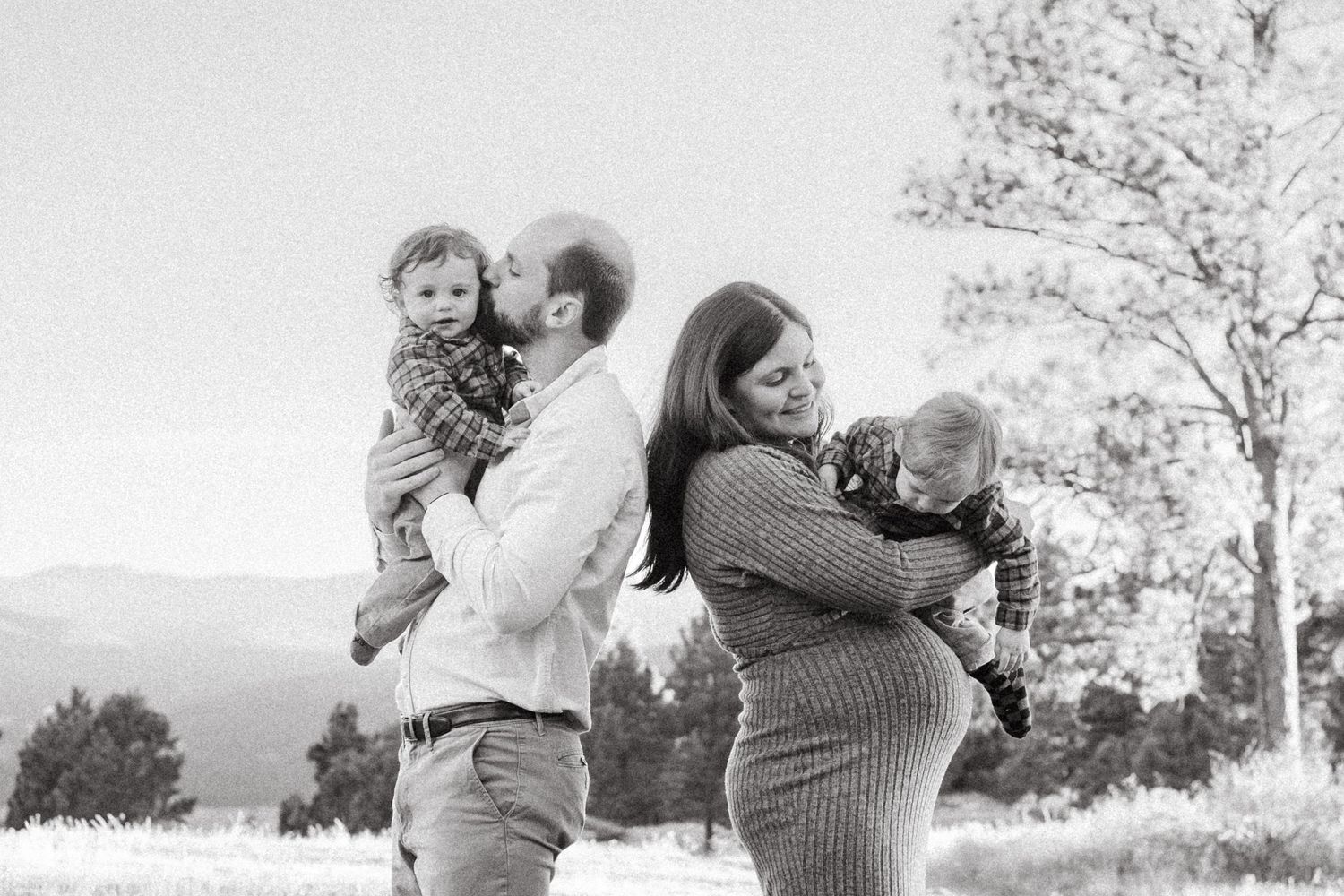 Black and white family photo of pregnant mother, father and twin boys with Denver family photographer at Mt Falcon West.