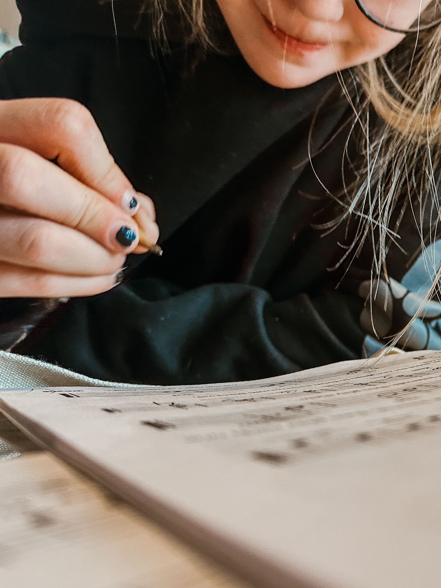 Close up of young girl holding pencil, doing piano theory work.