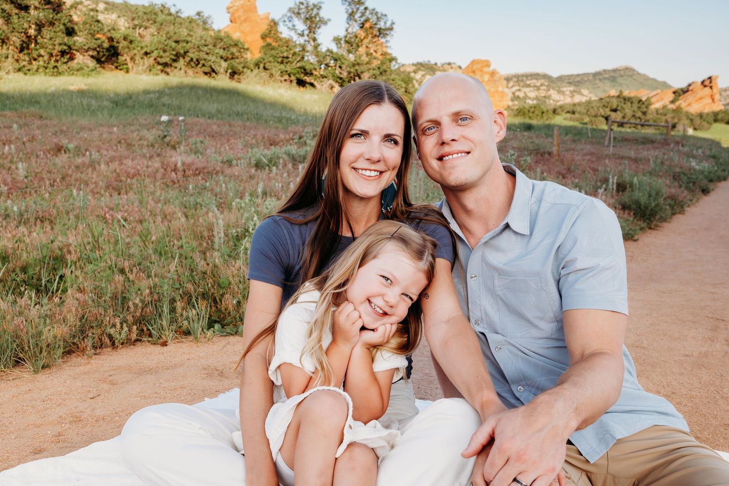 Family of three smiling at South Valley Park in Littleton Colorado.