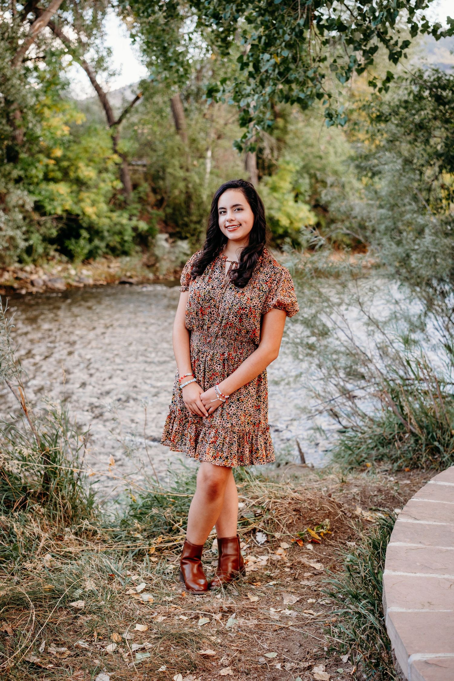 Senior photograph of Littleton graduate standing near Clear Creek river in Golden, Colorado.