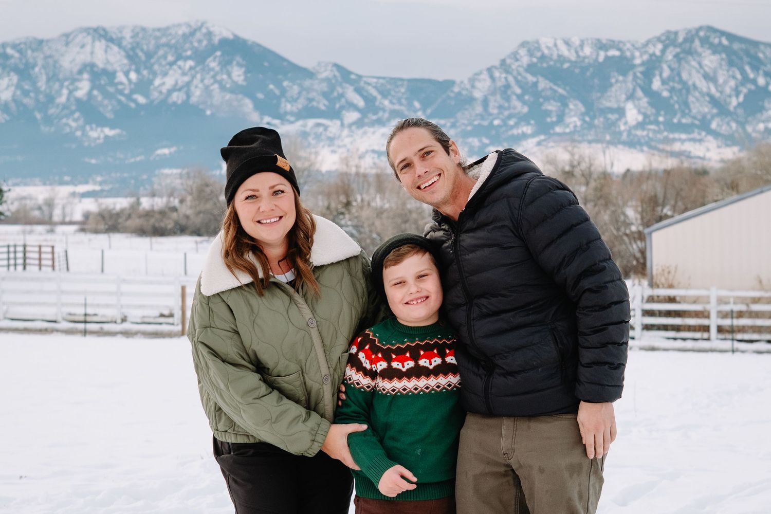 Mother, father and young son standing in front of Boulder flat irons, all smiling.