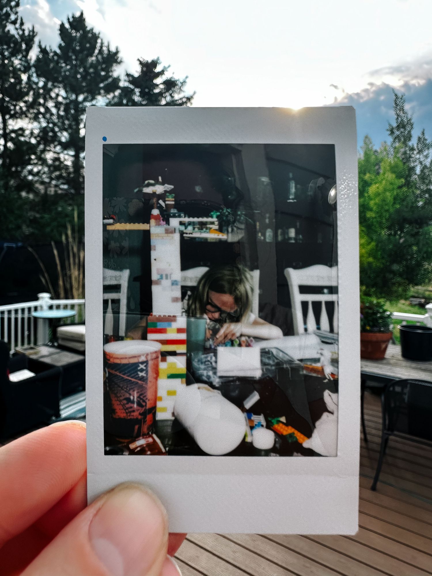 A photo of a polaroid of a girl at a table.