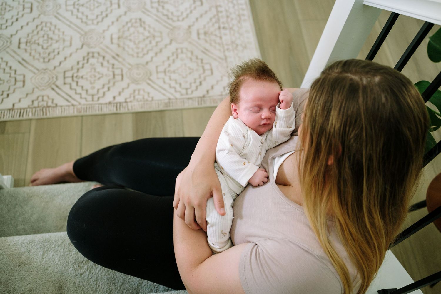 Mother holding newborn boy during Denver in-home photo session.