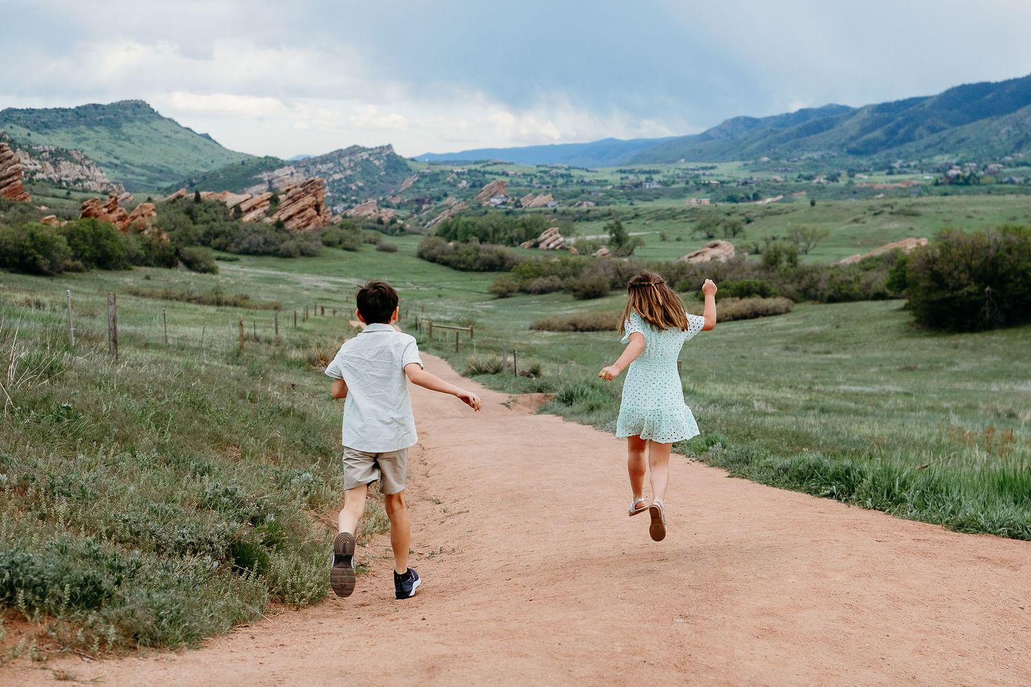 Kids running down trail during family mini session near Denver