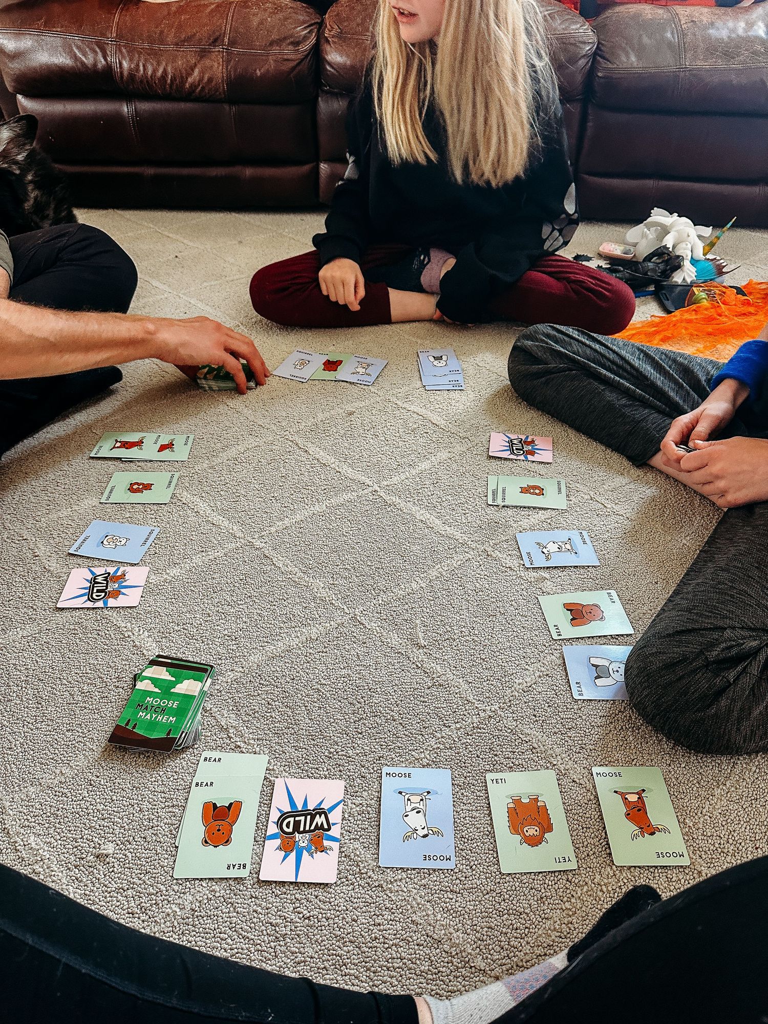 Family playing card game in living room.