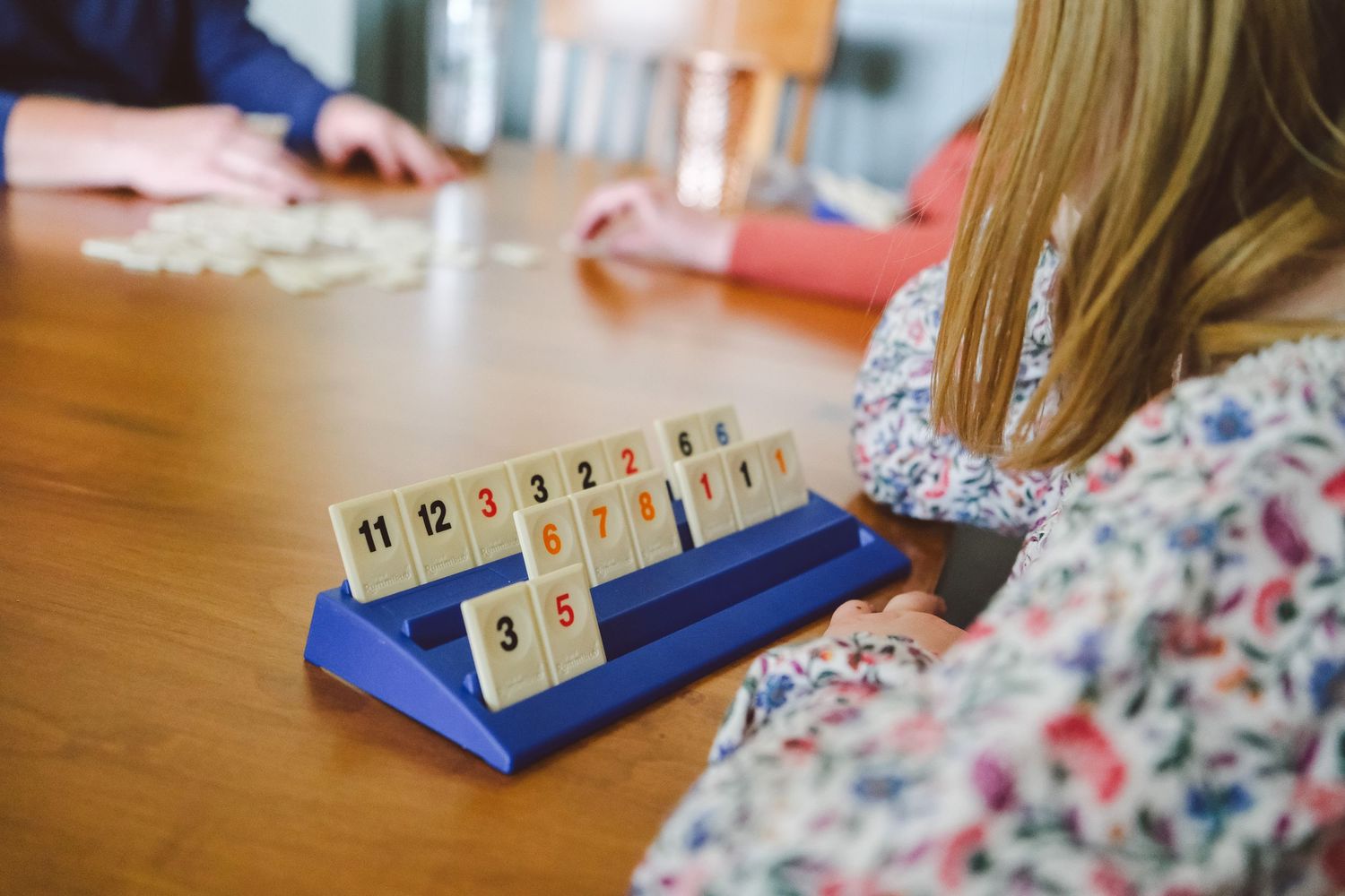In-home Denver family photography session,  family of four playing rumikub at dining table.