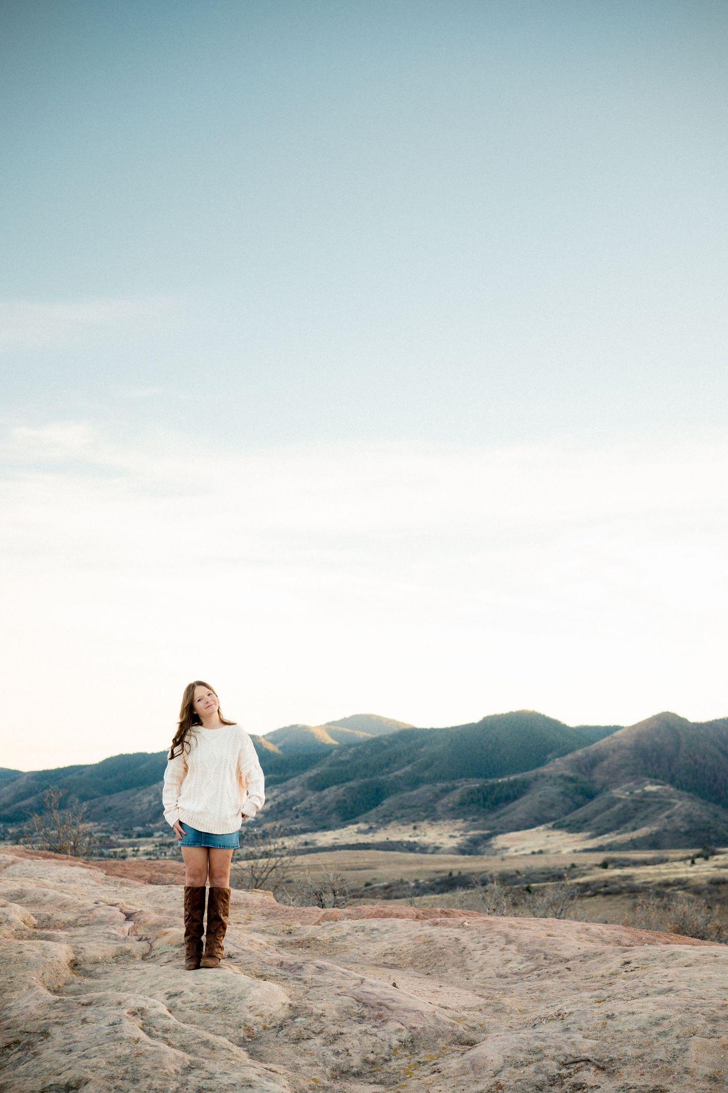 Teen girl standing on rock formations, gazing toward camera, at South Valley Par.