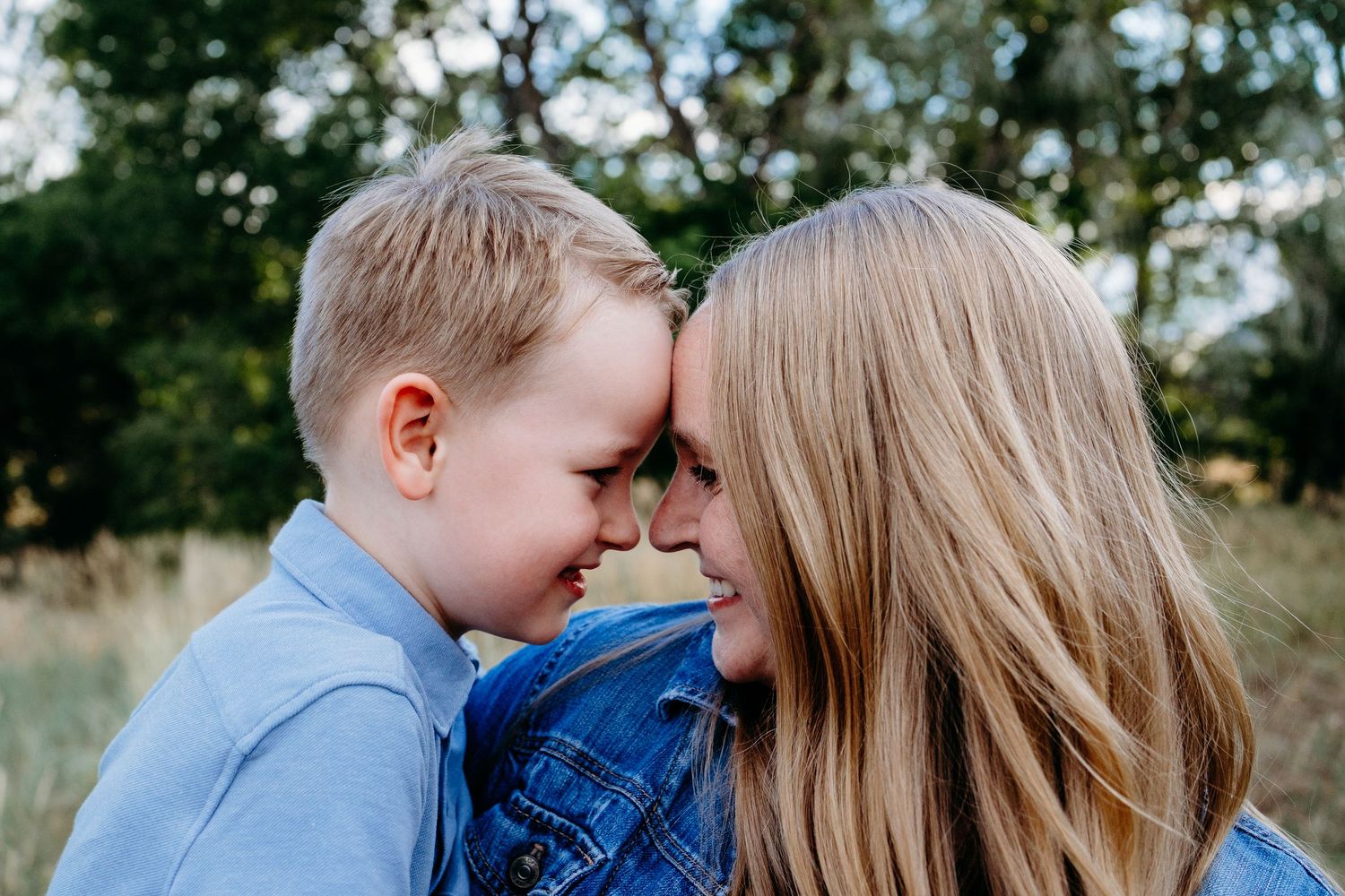 Mother and son pressing foreheads together, smiling.