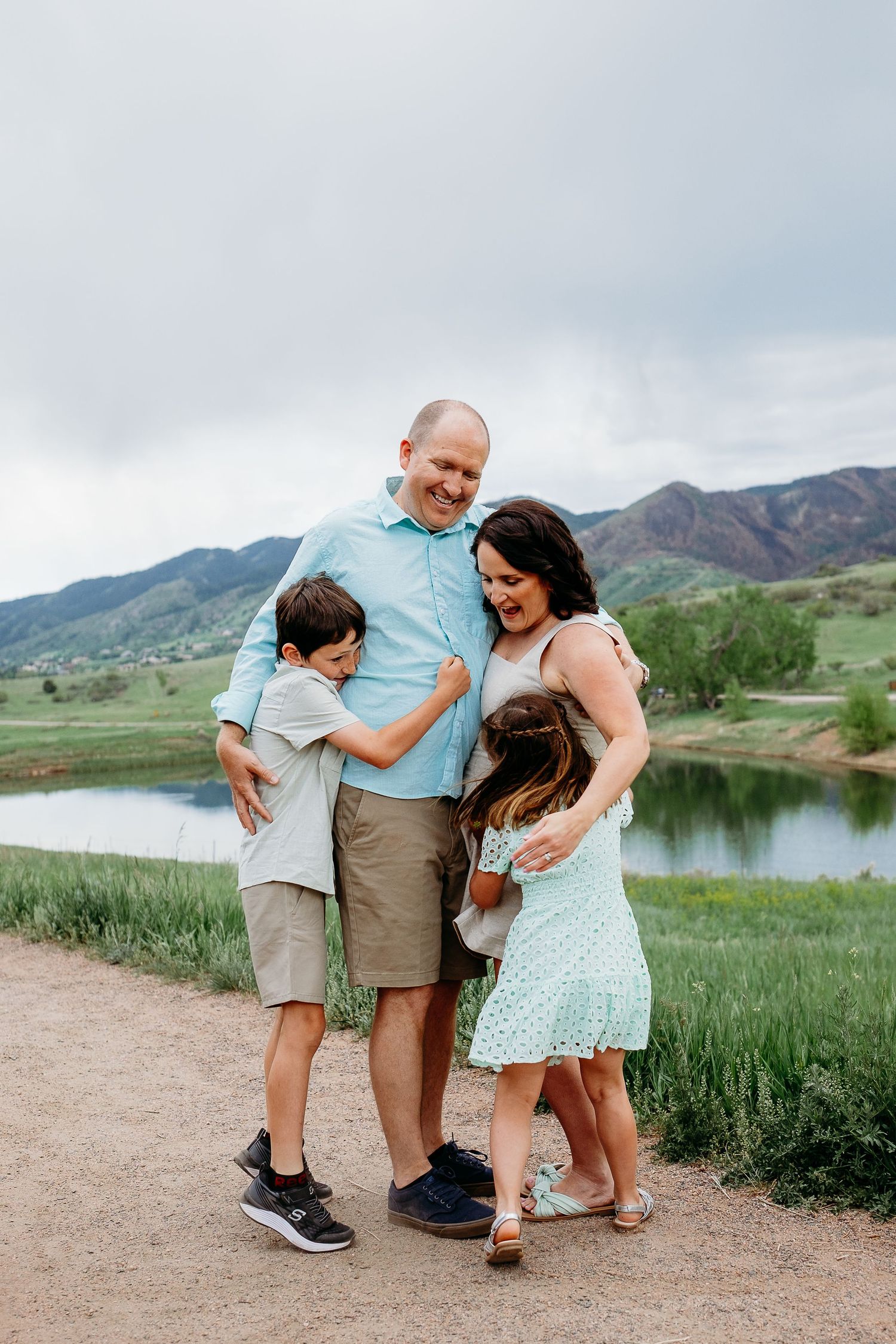 Laughing family of four at scenic foothill location in Colorado