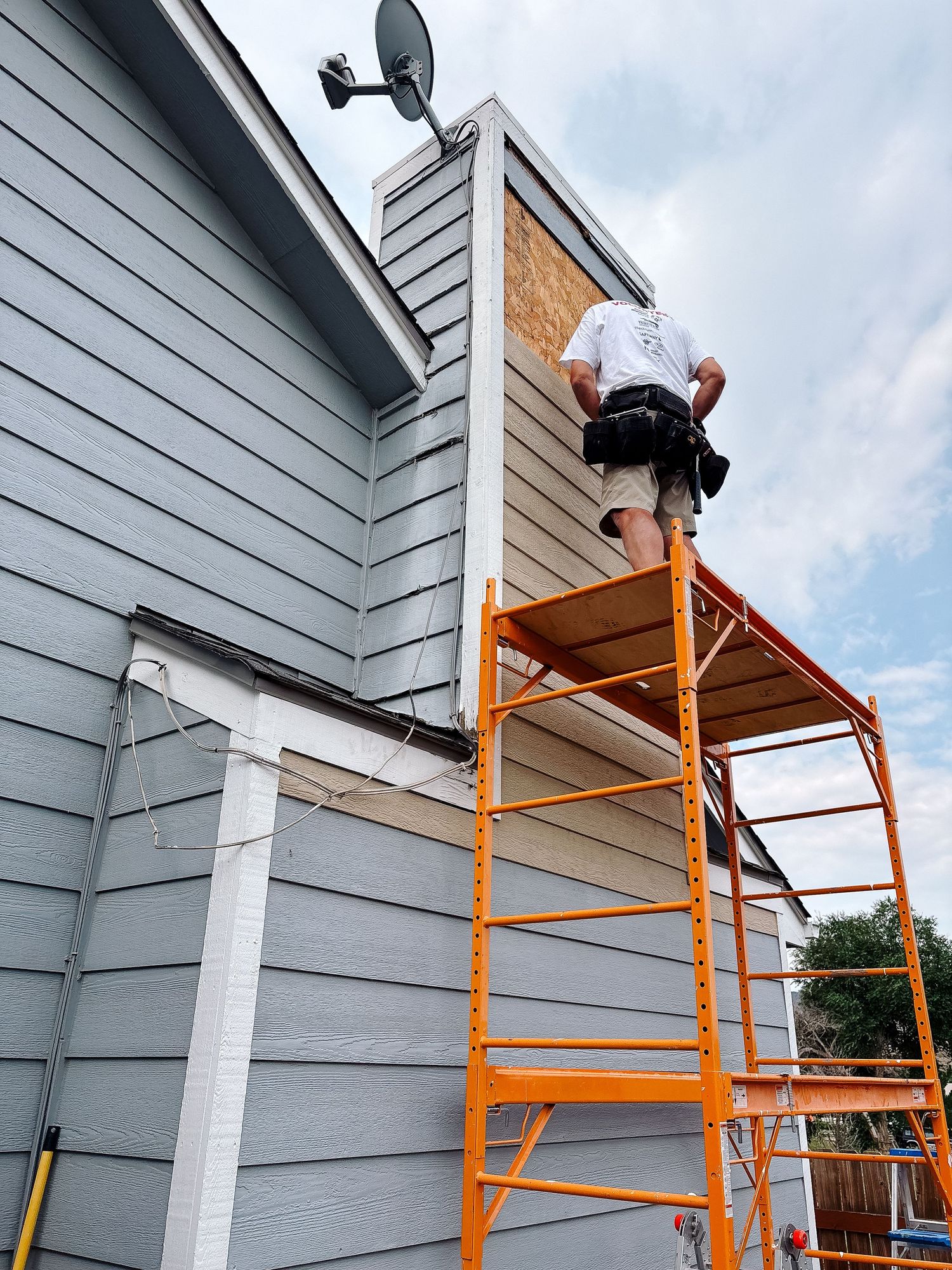 Project 365 photo - man working on scaffolding to repair siding.