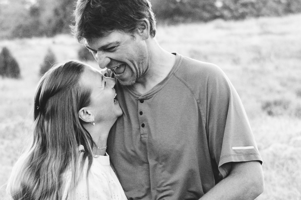 Mother and father laughing in black in white portrait.