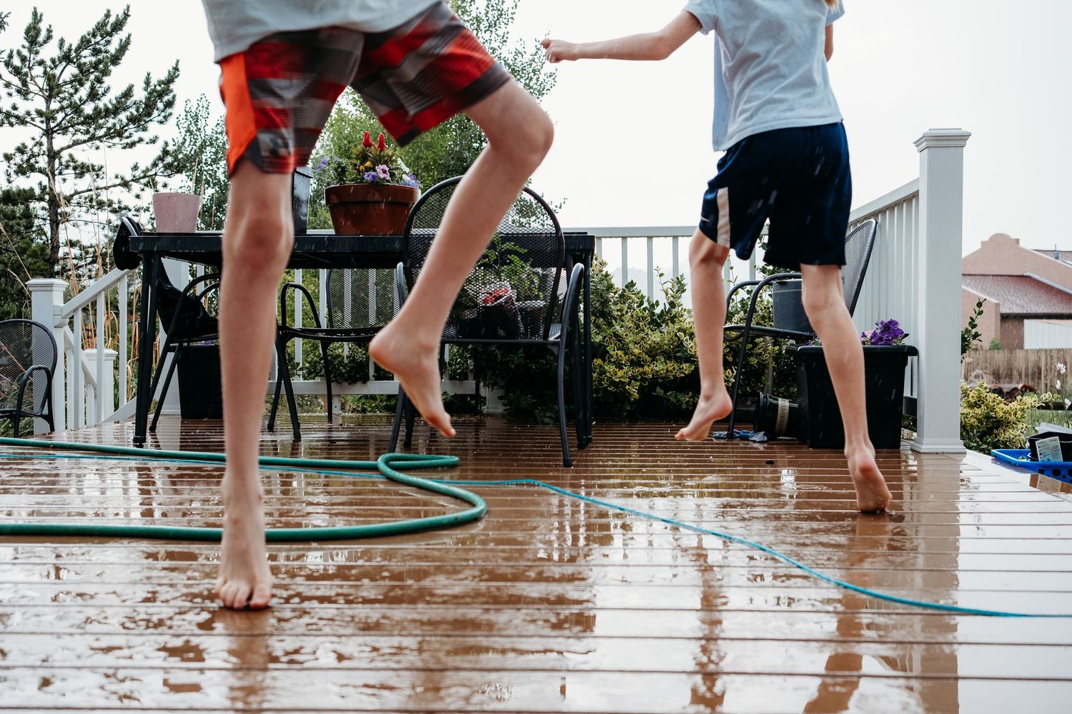 Children playfully jumping in rain in background.