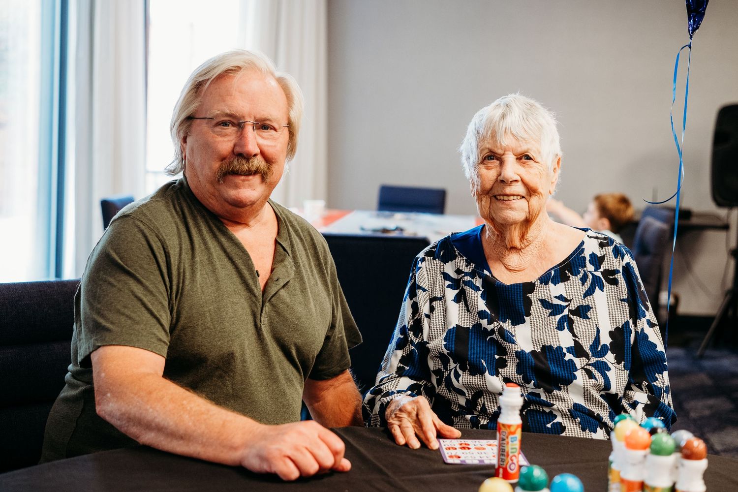 Father and mother sitting posed together for mother's 90th birthday party in Denver event documentary session.