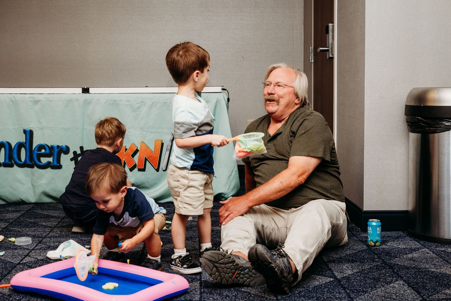 Grandfather playing on the floor with three grandchildren.