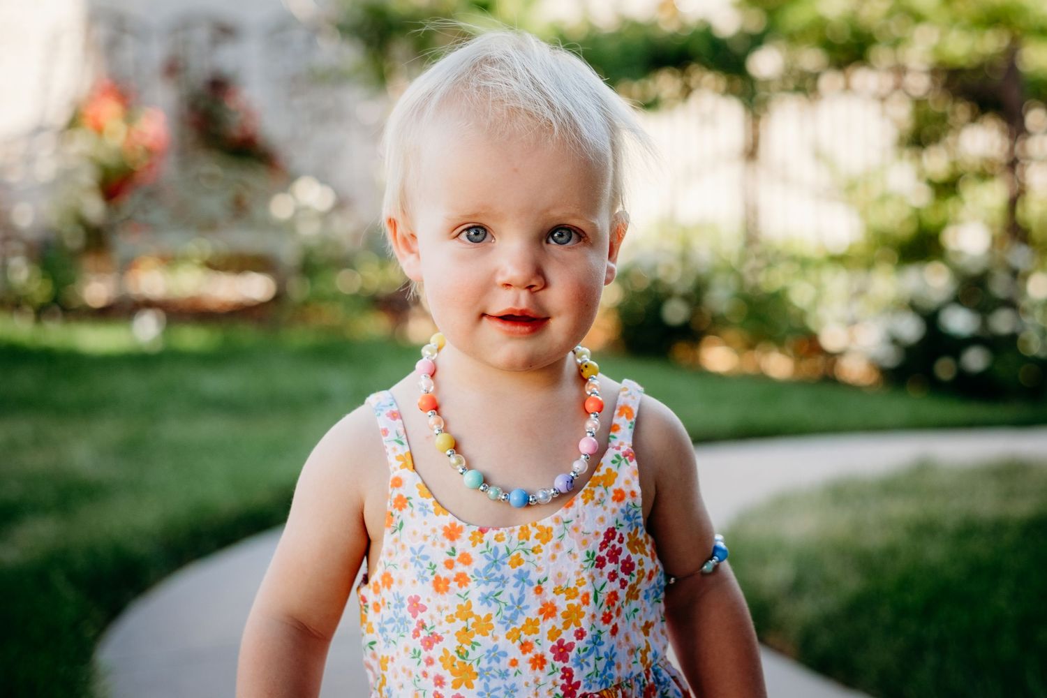 Close up portrait of darling blond toddler, looking curiously toward camera.