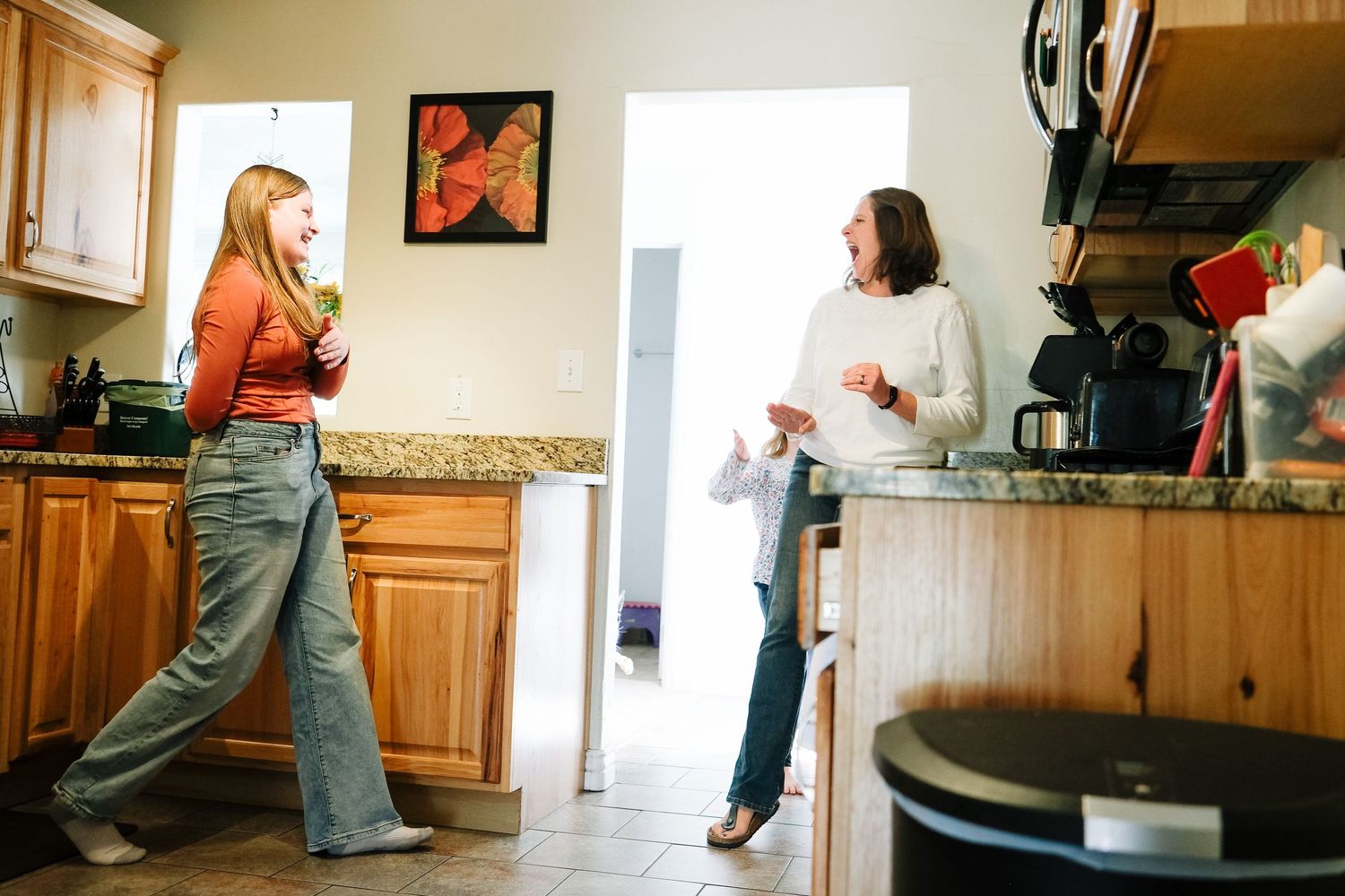 Denver family having a playful dance party in kitchen.