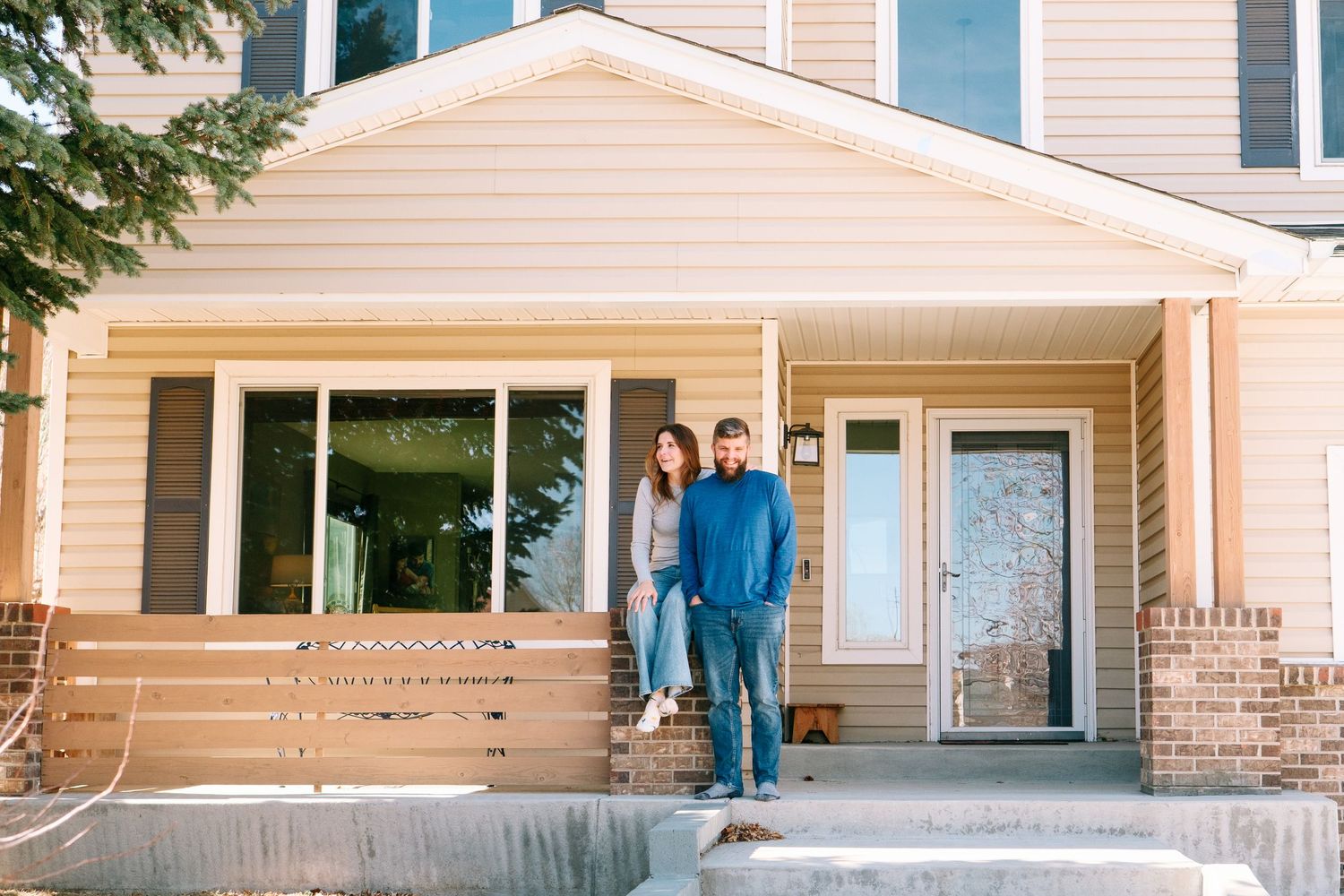 Mother and father sitting on front porch of home, both looking in different directions.
