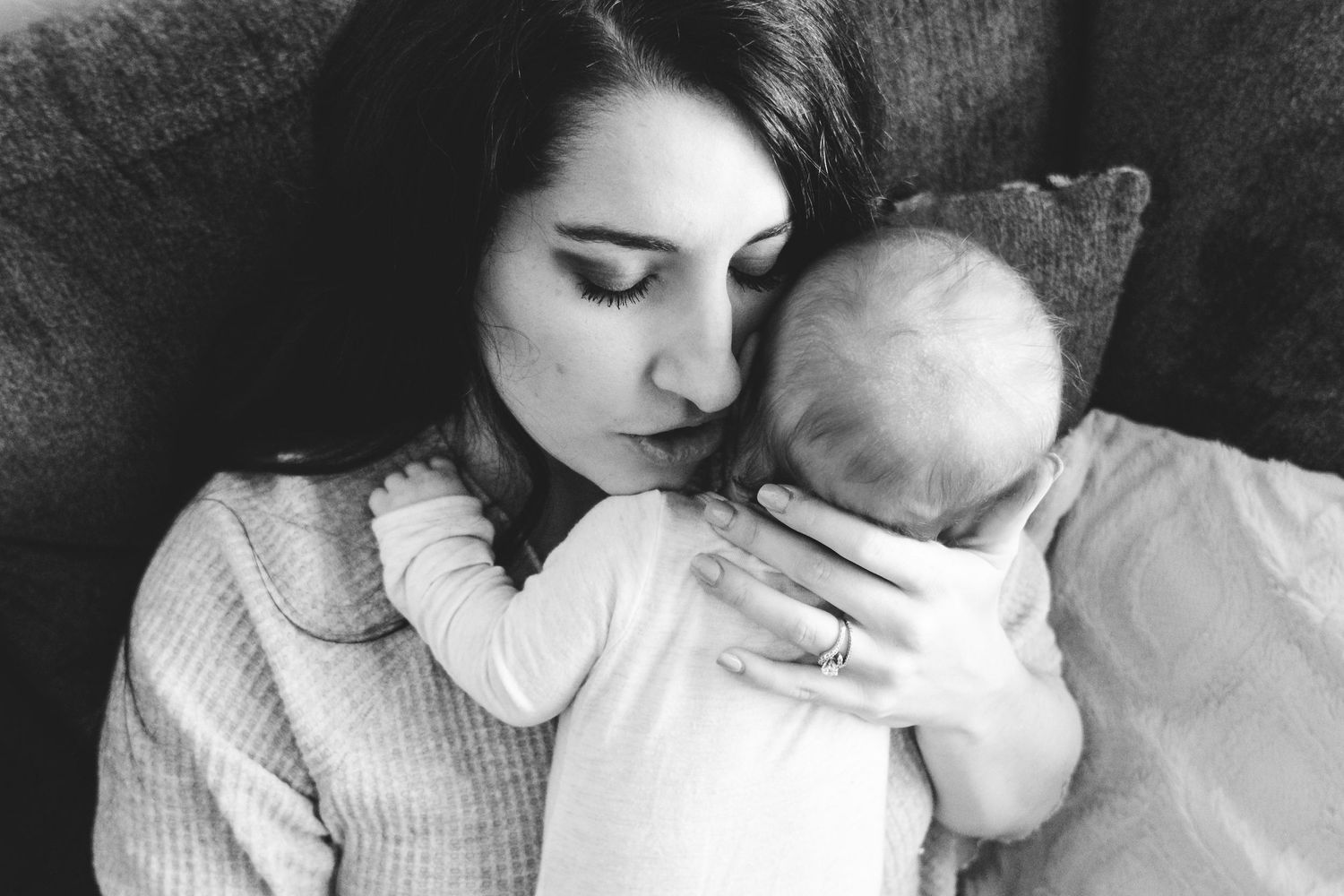 Close up of mother holding newborn baby closely to her face, making a comforting, 