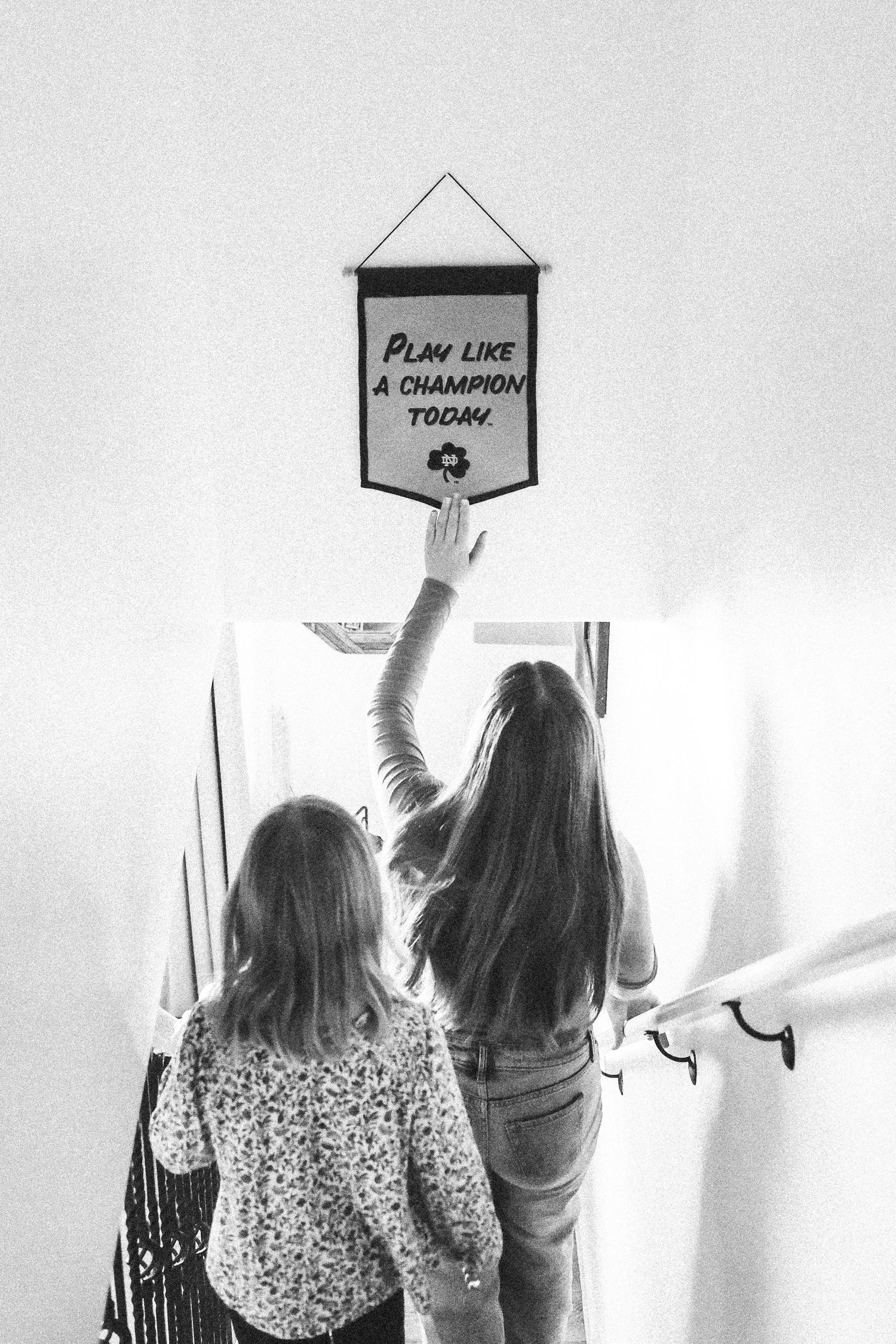 Sisters walking down stair case, Notre Dame banner hung in hallway above stairs.
