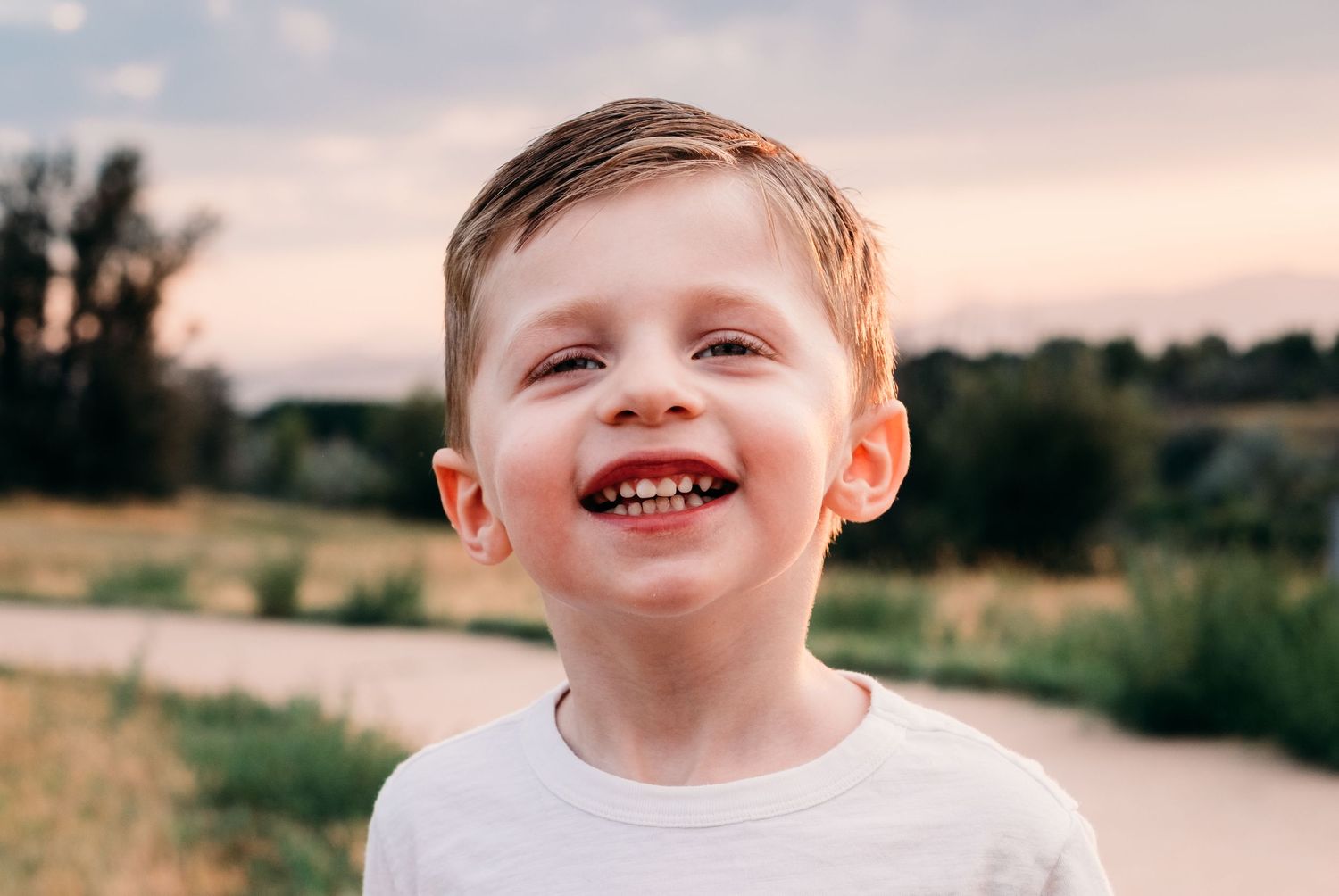 Close up portrait of young boy, sunset in background.