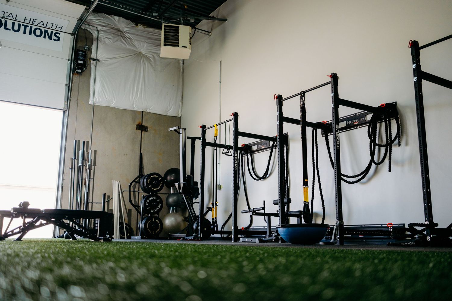 A gym shot of several weight lifting racks shot from a low perspective.