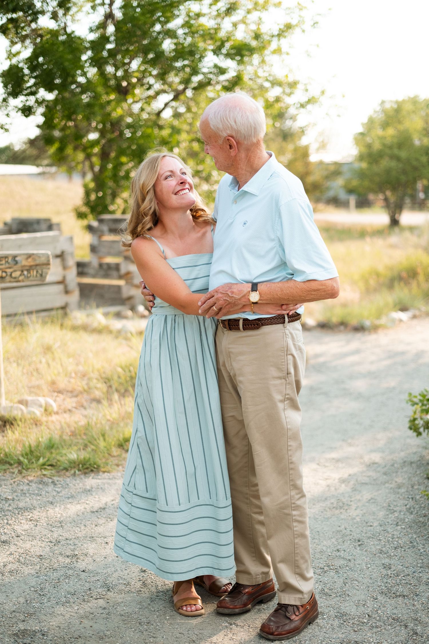 Adult daughter hugging father on a summer day at a Denver park.
