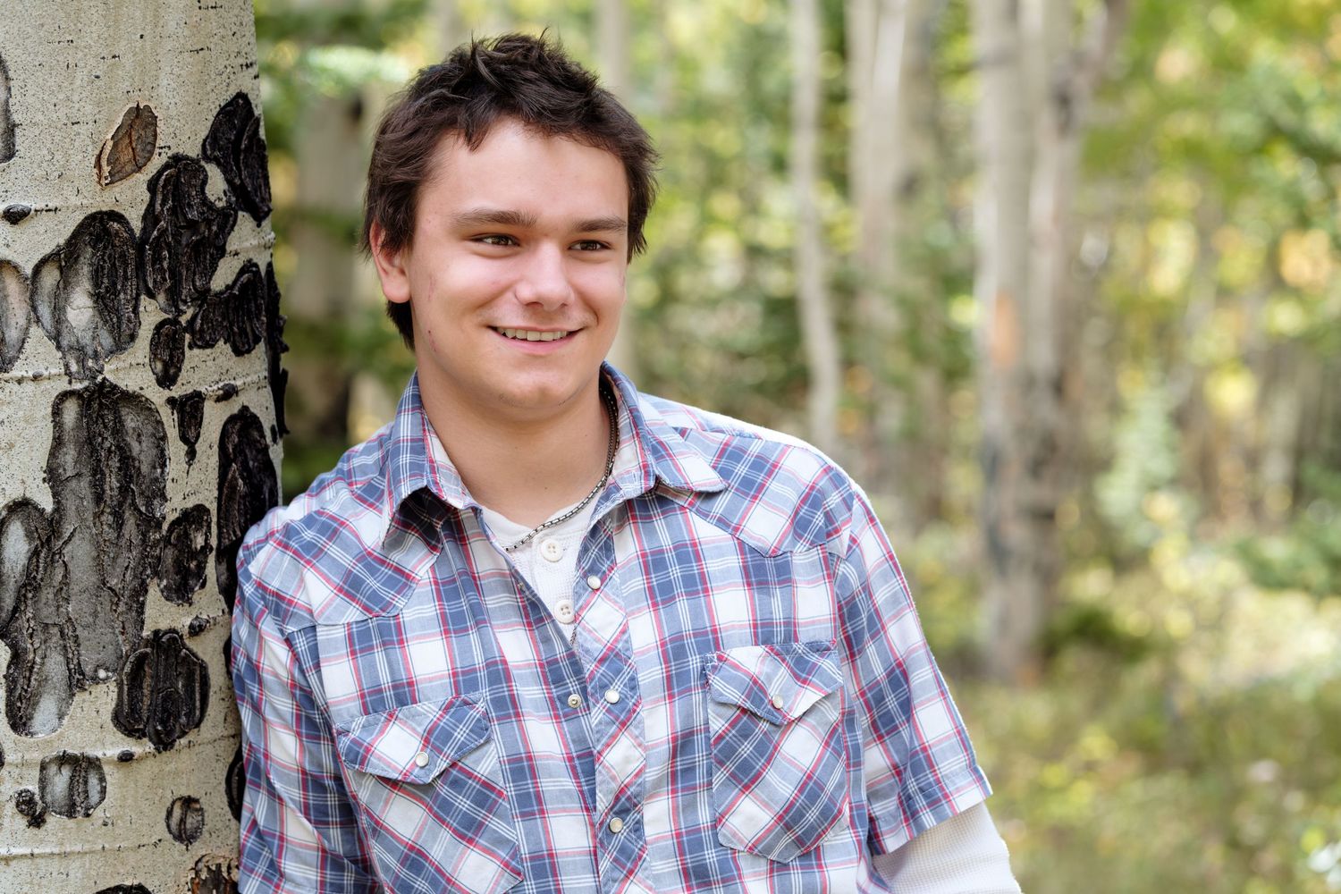Teen boy smiling in the mountains of Colorado.