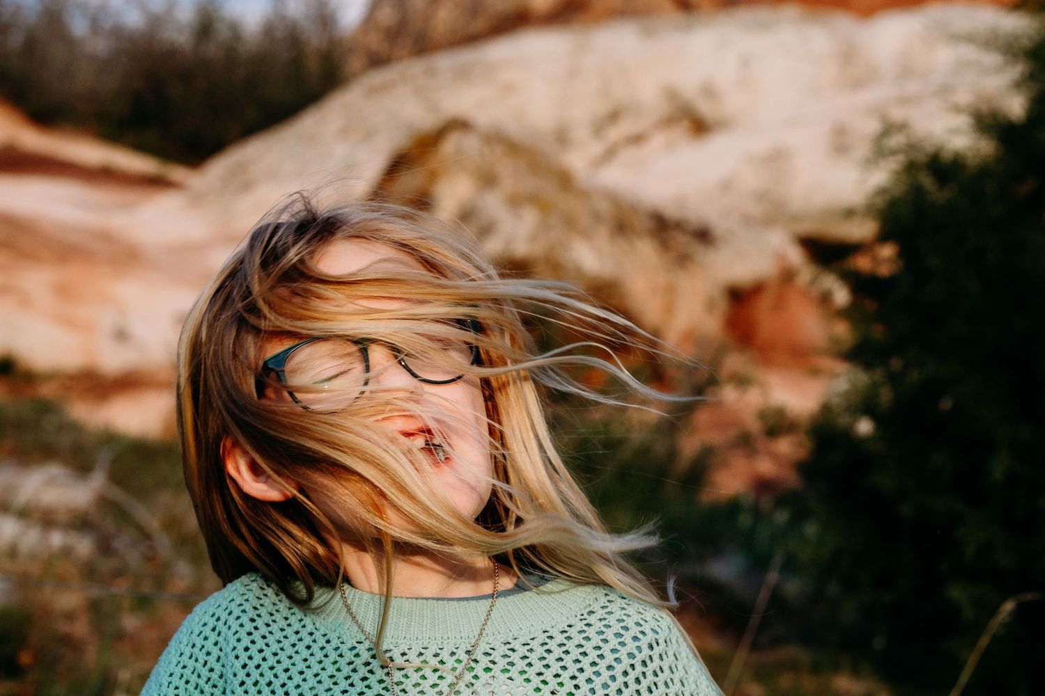 Denver photographer's project 365, May, young girl with blond hair blowing in her face, red rocks in background.
