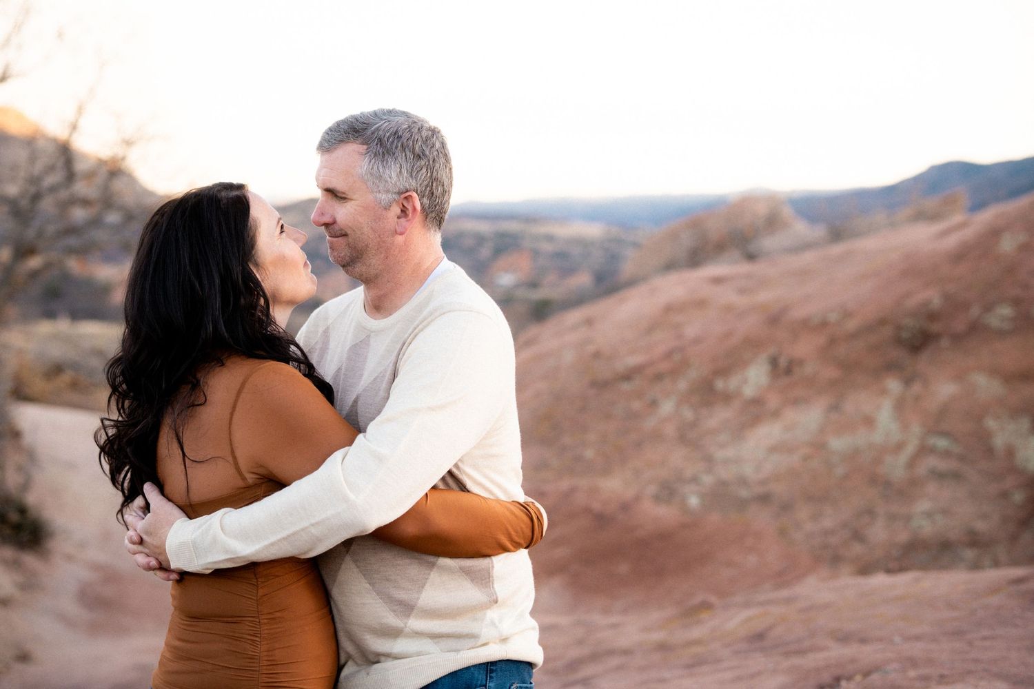 Adult couple embracing one another, gazing at each other, at S Valley Park near Denver, CO.