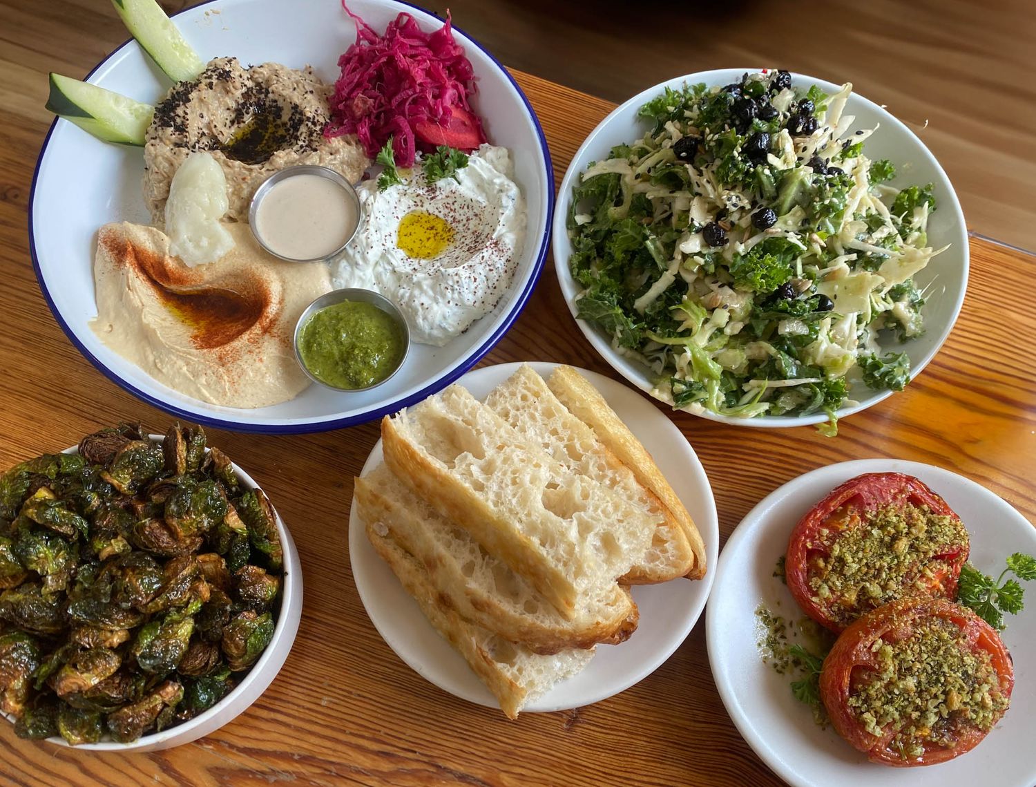 Middle Eastern mezze spread featuring hummus, falafel, pita bread, pickled vegetables and fresh salads.