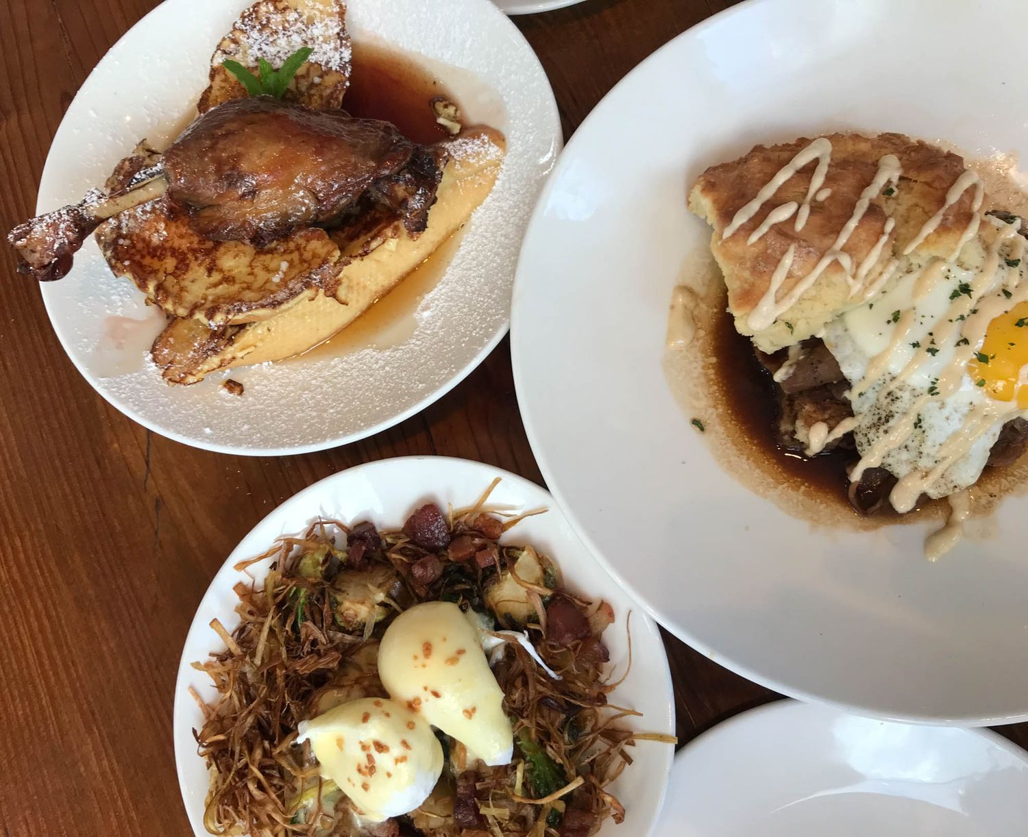 Overhead view of three plated dishes featuring braised meat, poached eggs over greens, and creamy drizzled entrees.