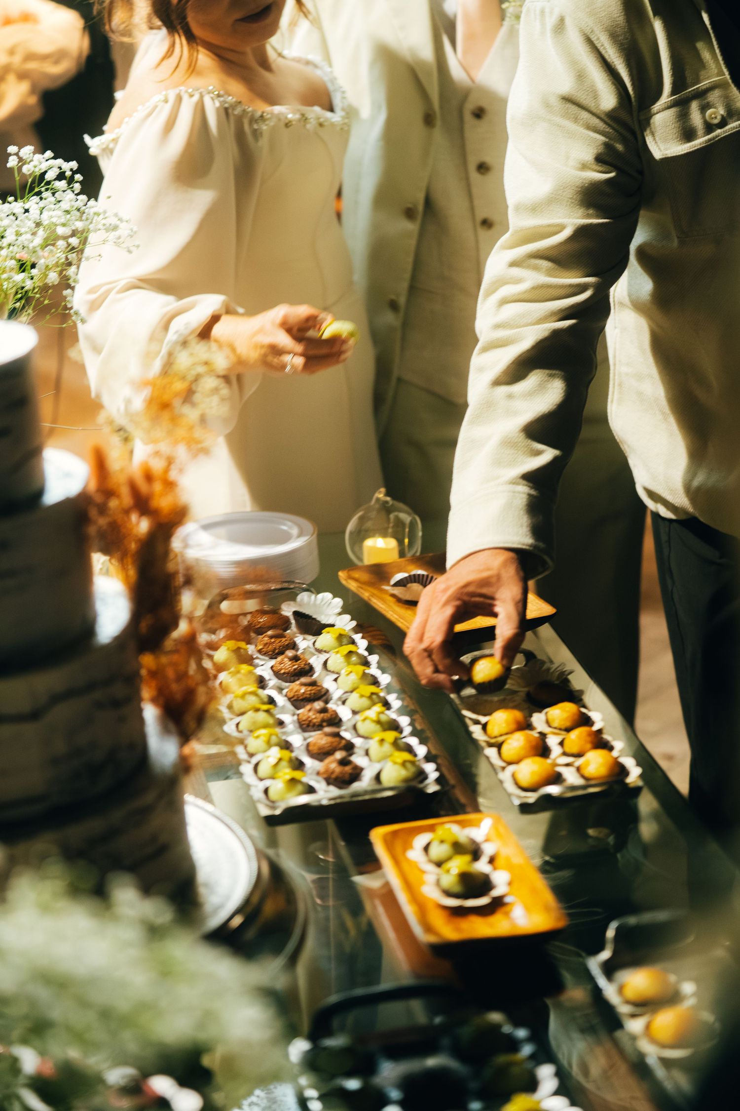 Catering staff serving appetizers on wooden boards at an outdoor event.
