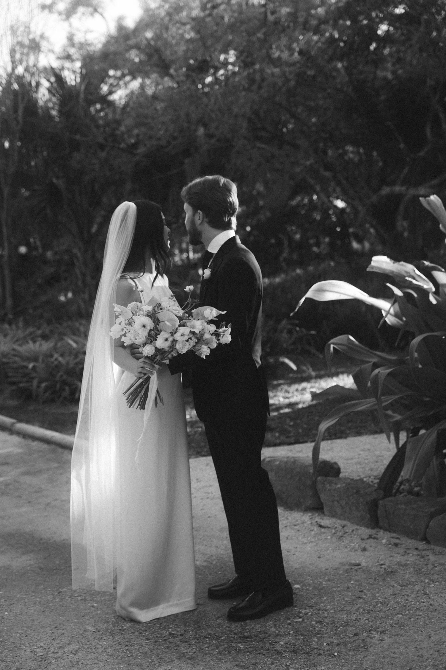 Black and white wedding photos showing couple walking together outdoors.