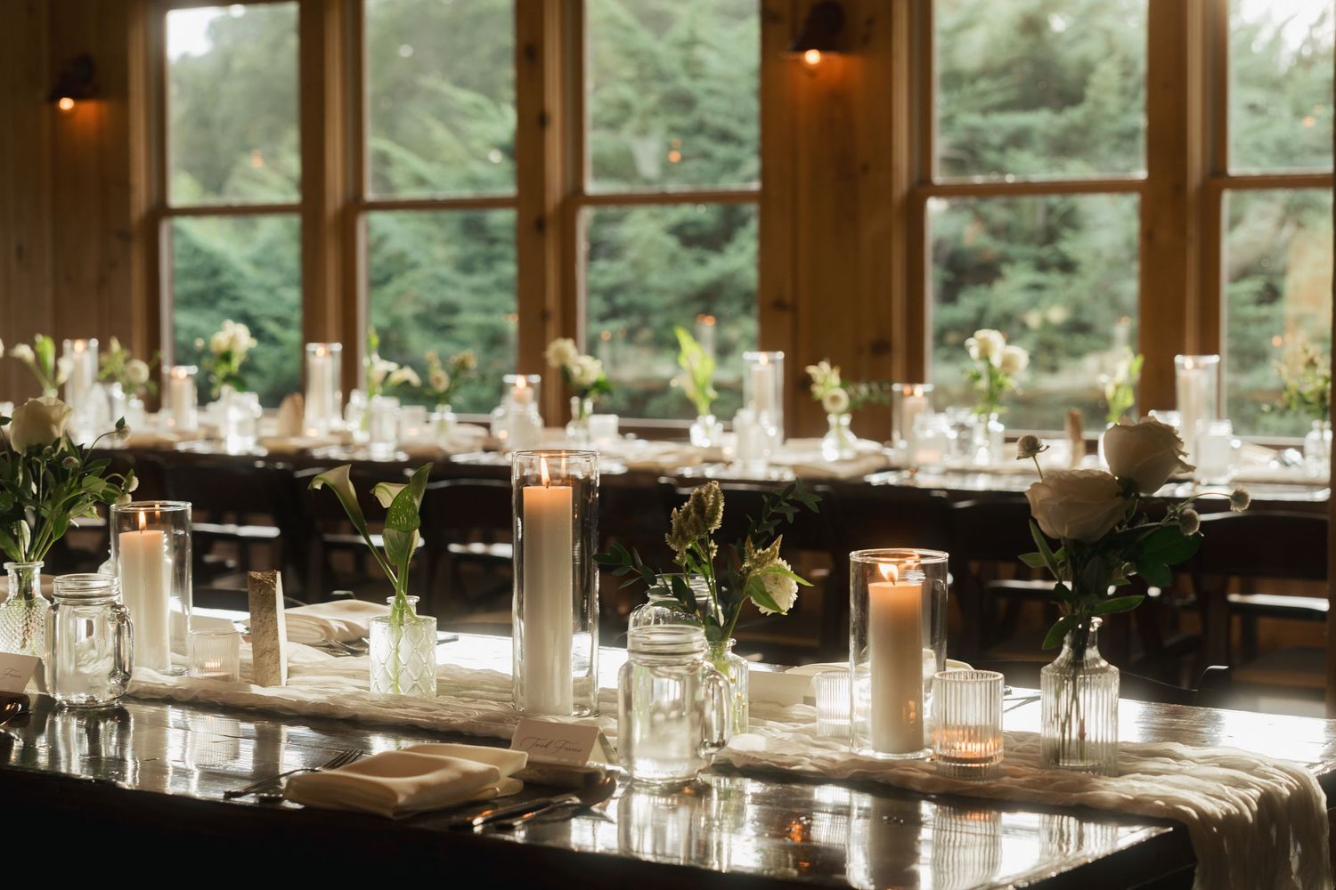 Elegant wedding reception venue with candlelit tables and large windows.