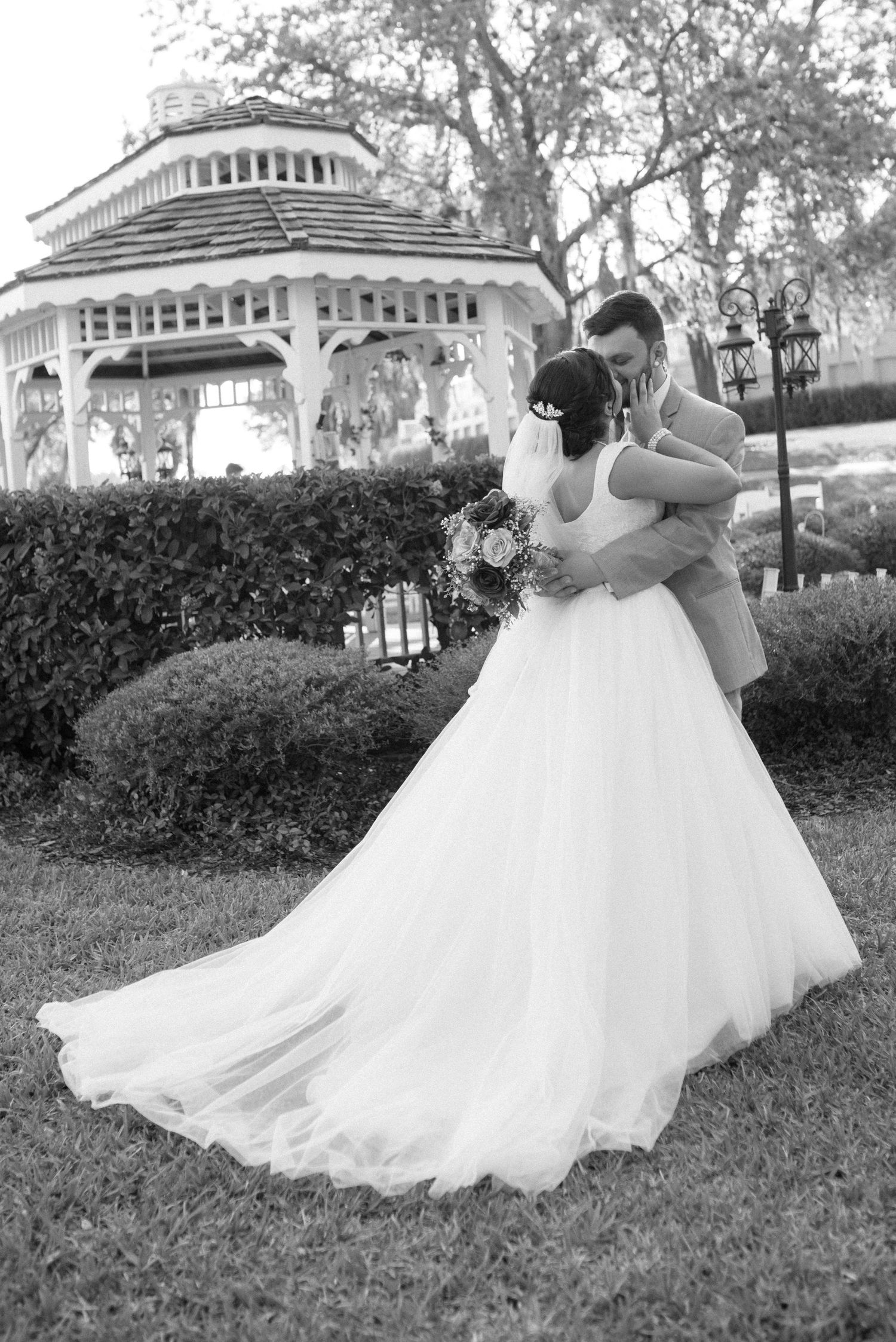 Flowing white wedding dress twirls gracefully against a garden backdrop.