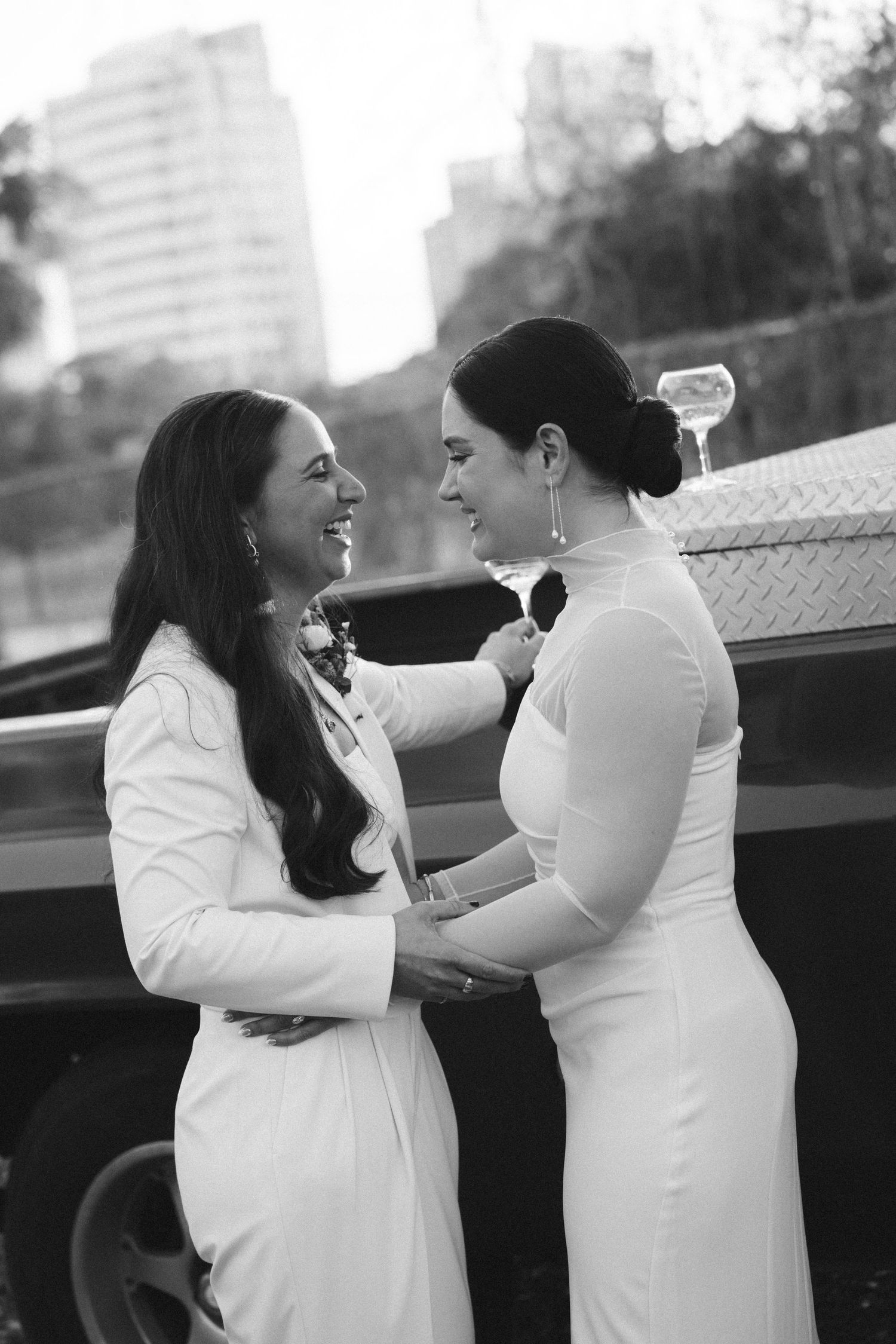 Black and white wedding portrait series showing a romantic moment between two people in white outfits.