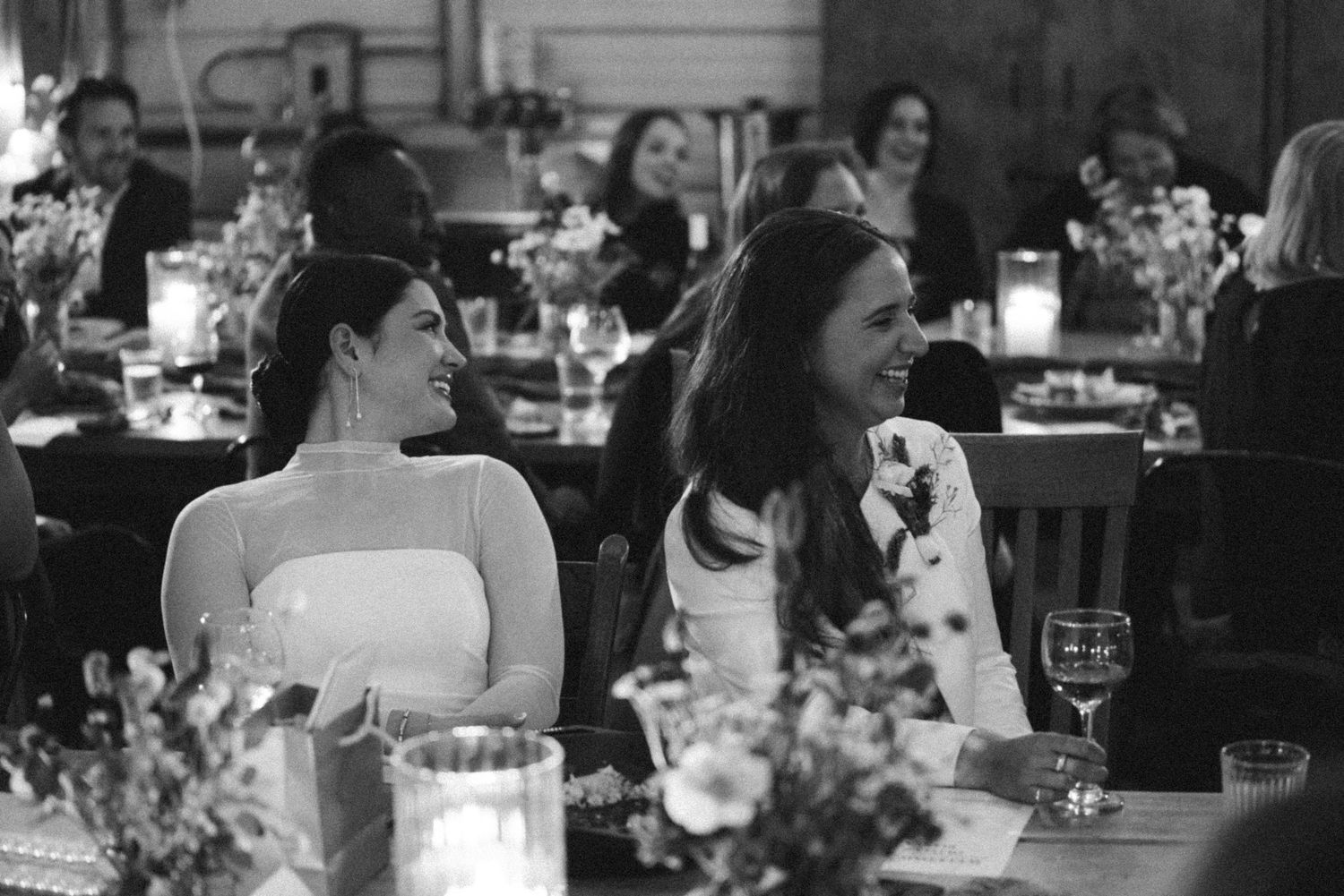 Black and white photo of wedding reception dinner with elegant table settings.