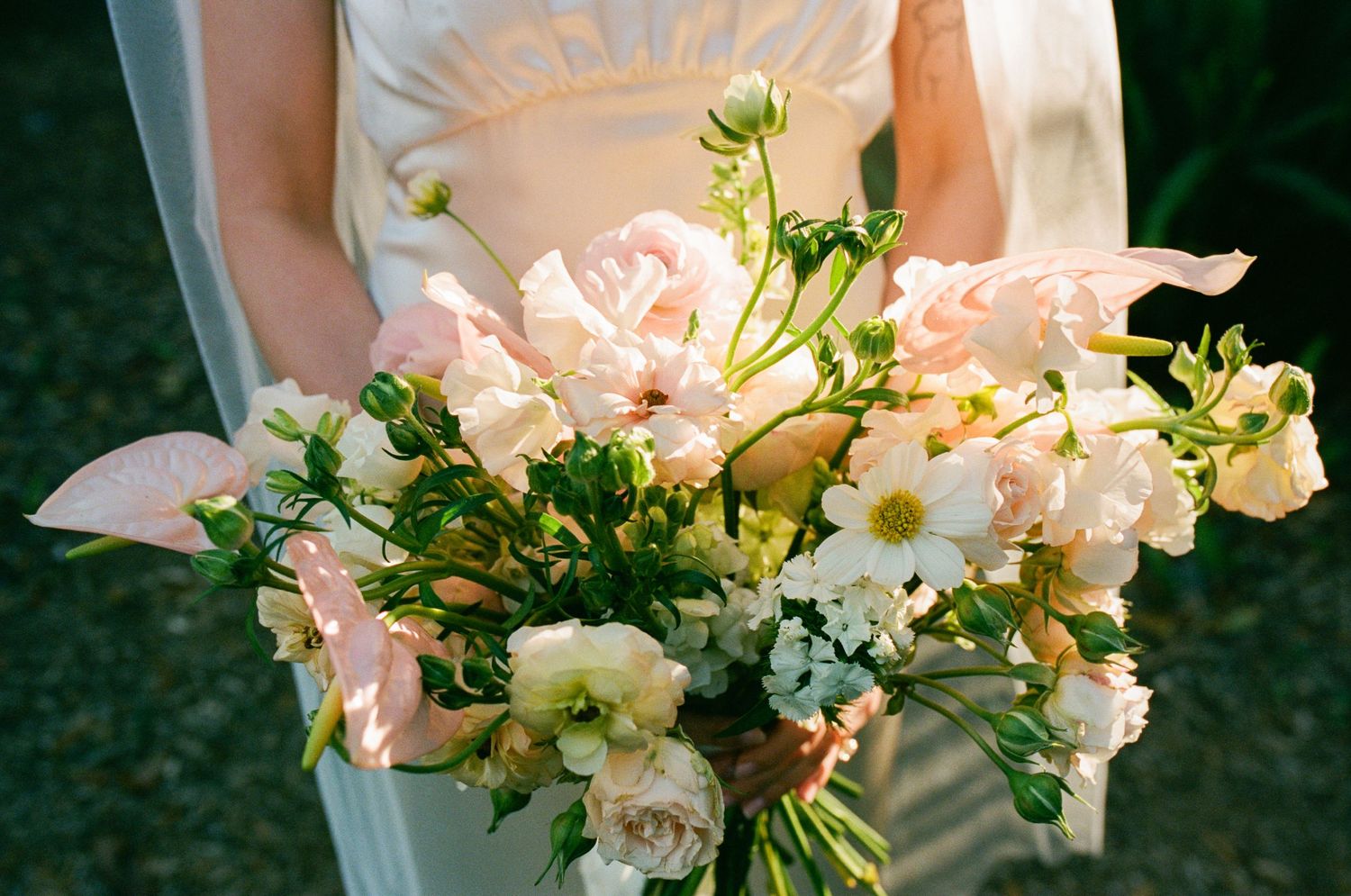 Close-up of a romantic spring wedding bouquet with pink and white roses.