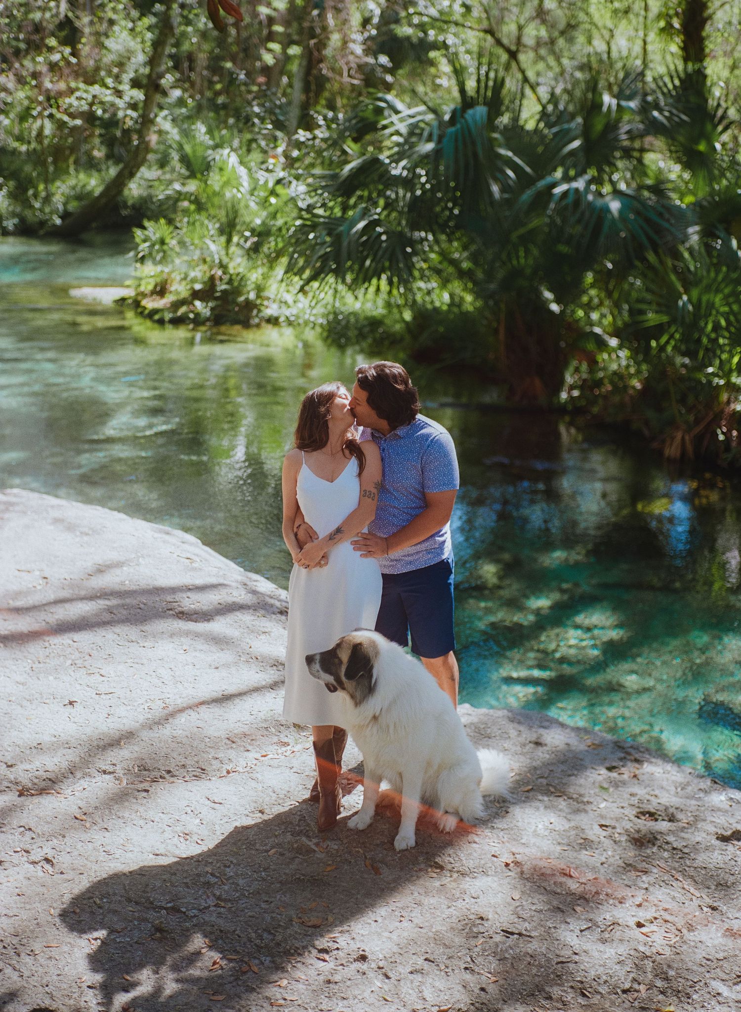Couple and their dog sharing intimate moments by crystal clear springs.