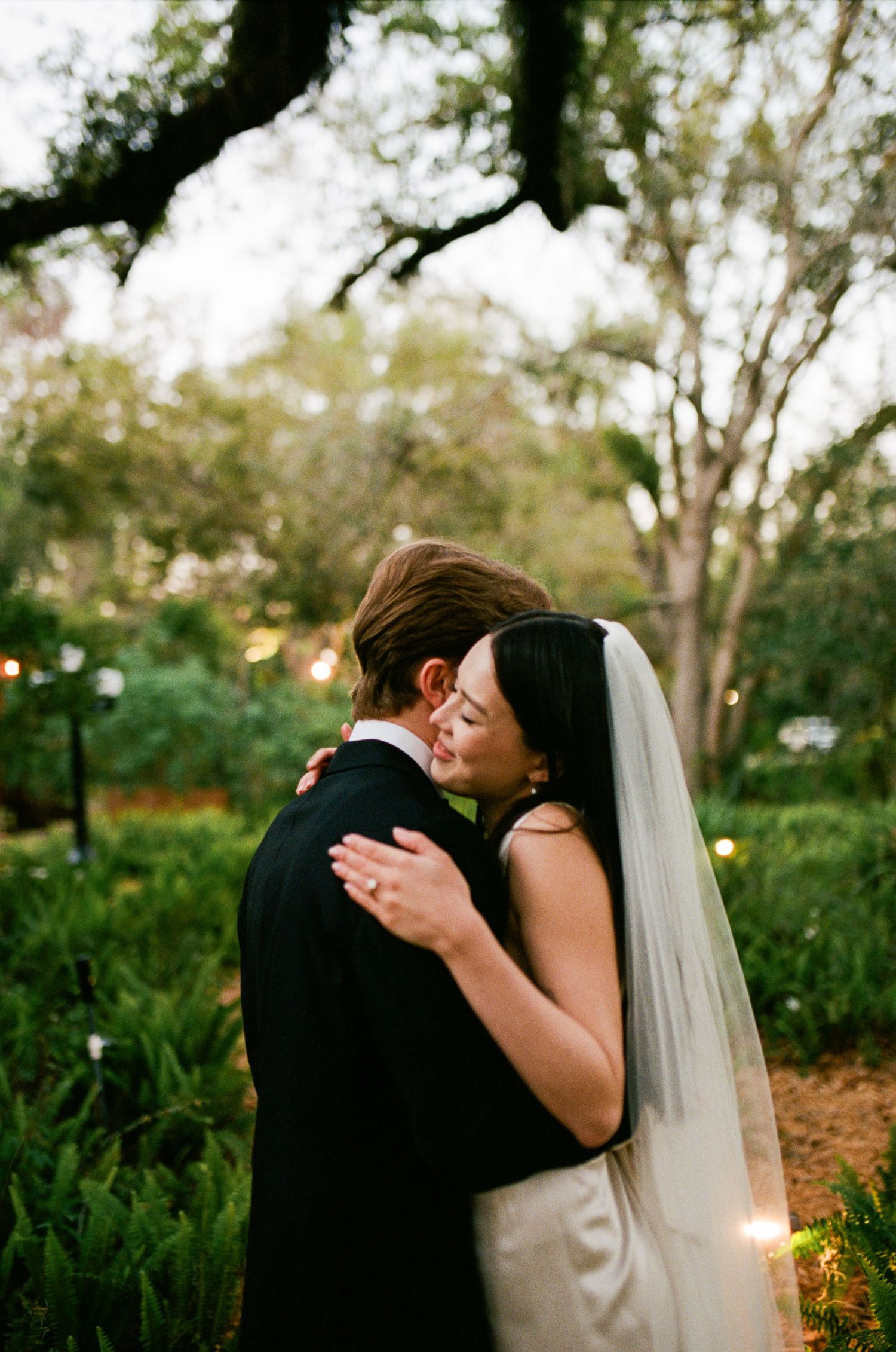 A romantic wedding moment captured in a lush garden setting during golden hour.