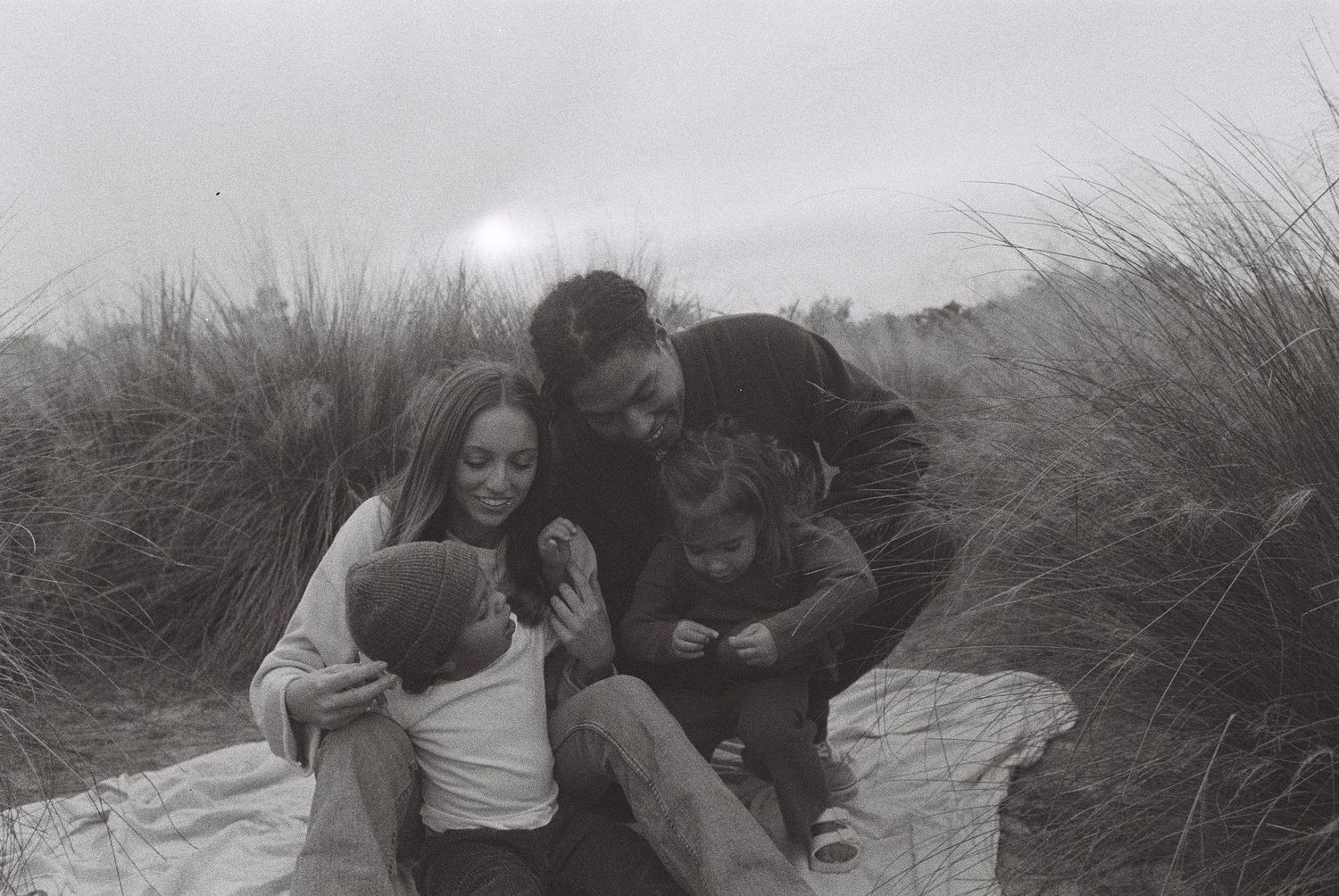 Series of romantic black and white photos taken in tall grass at sunset.