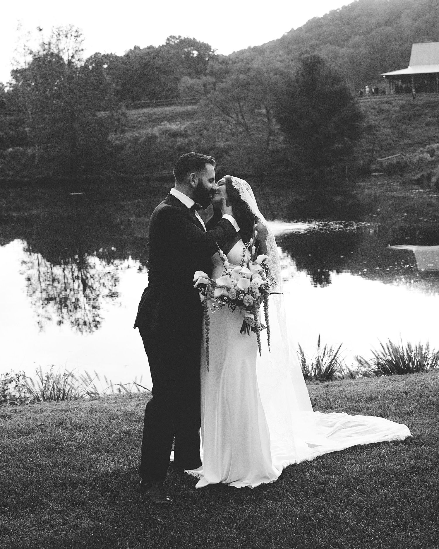 Black and white wedding photos showing couple by lakeside in romantic outdoor setting with water reflections.