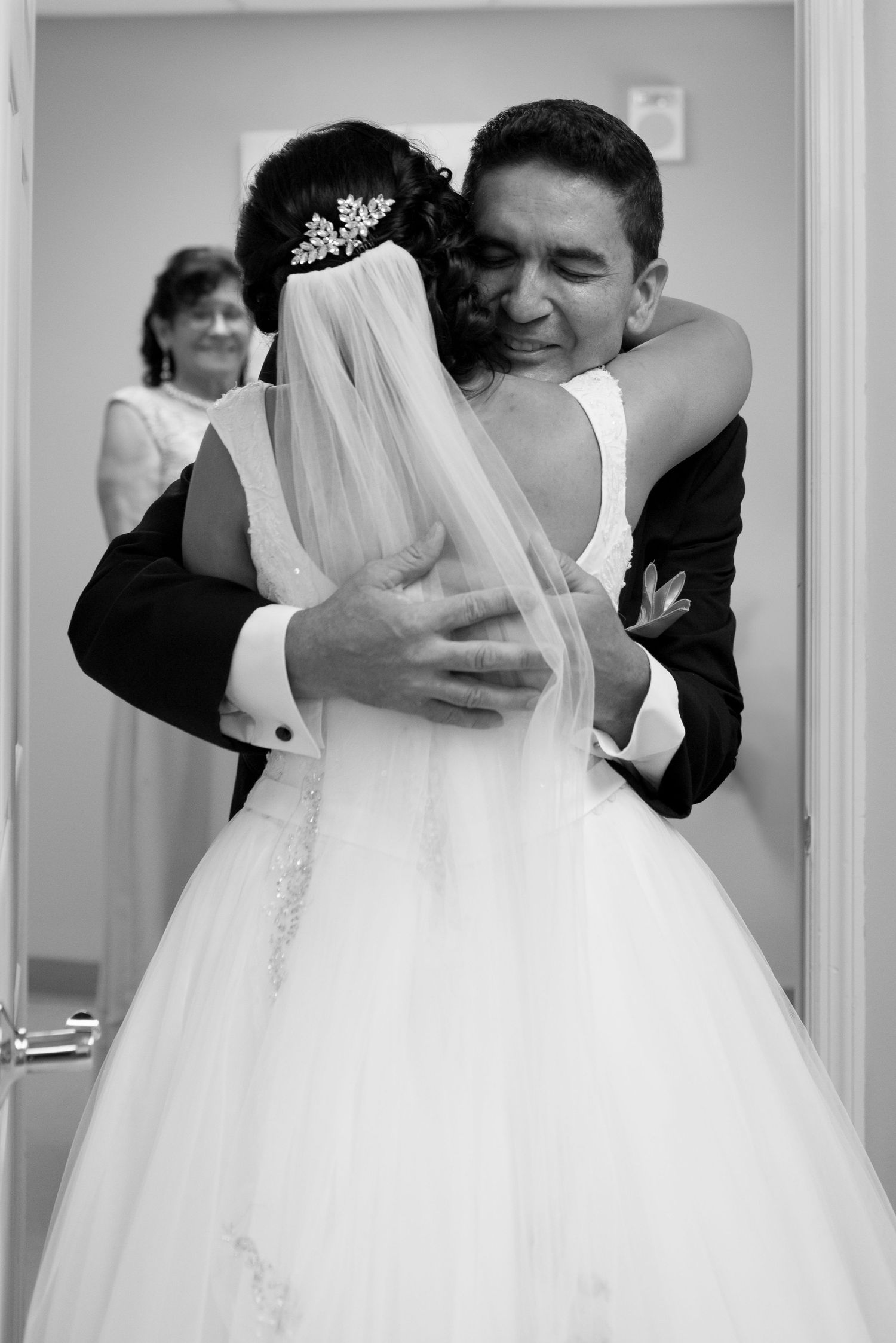 Multiple wedding dresses displayed in a bridal boutique with intricate details visible.