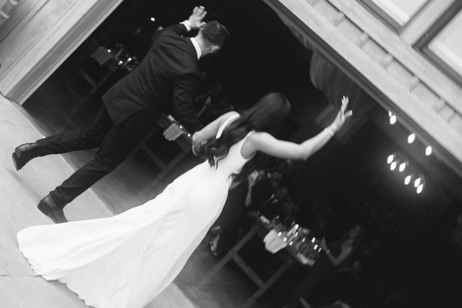 Black and white photo of a dramatic wedding dance dip on the dance floor.