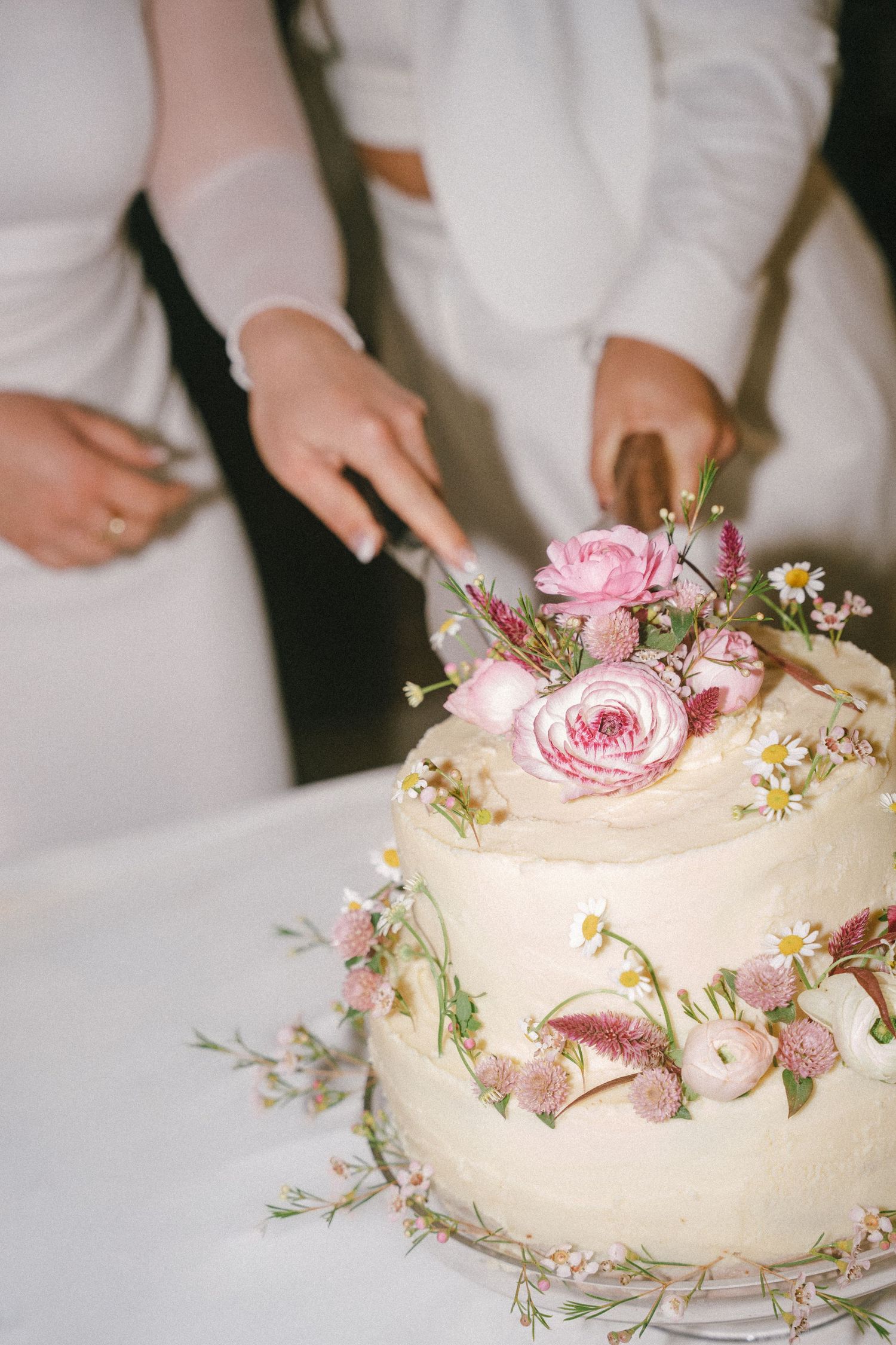 Beautiful white wedding cake decorated with fresh pink roses and delicate floral accents.