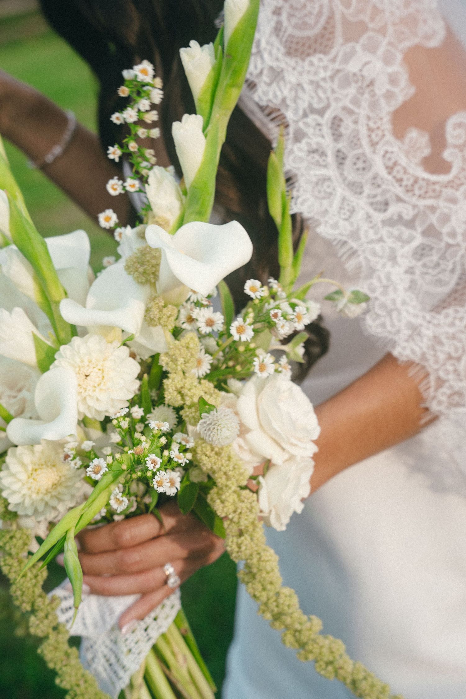 Elegant white bridal bouquet with lilies and delicate baby's breath flowers.